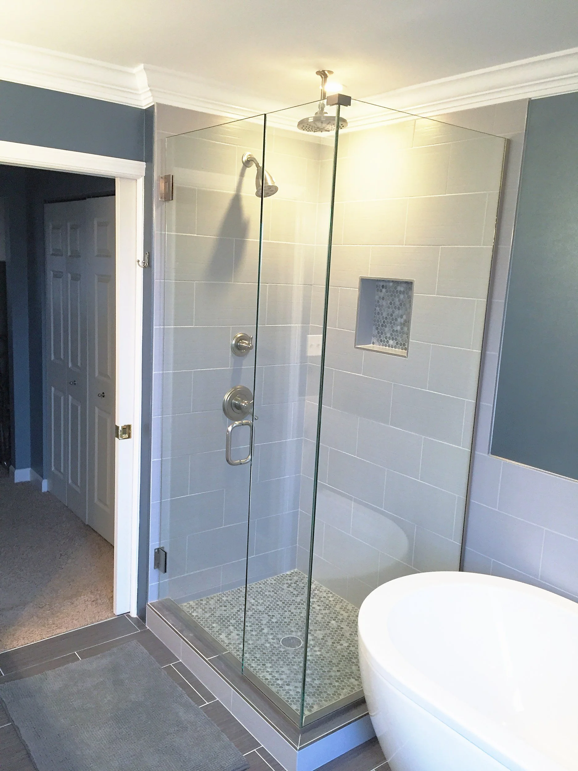 Frameless glass shower next to a freestanding tub