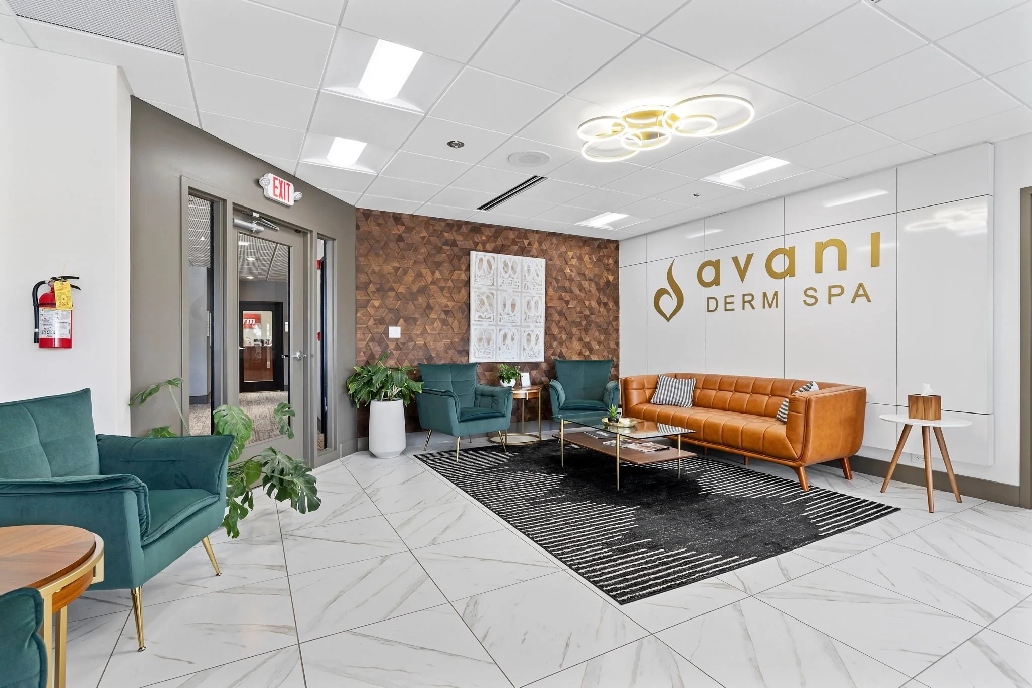 Lounge with a brick accent wall and teal chairs