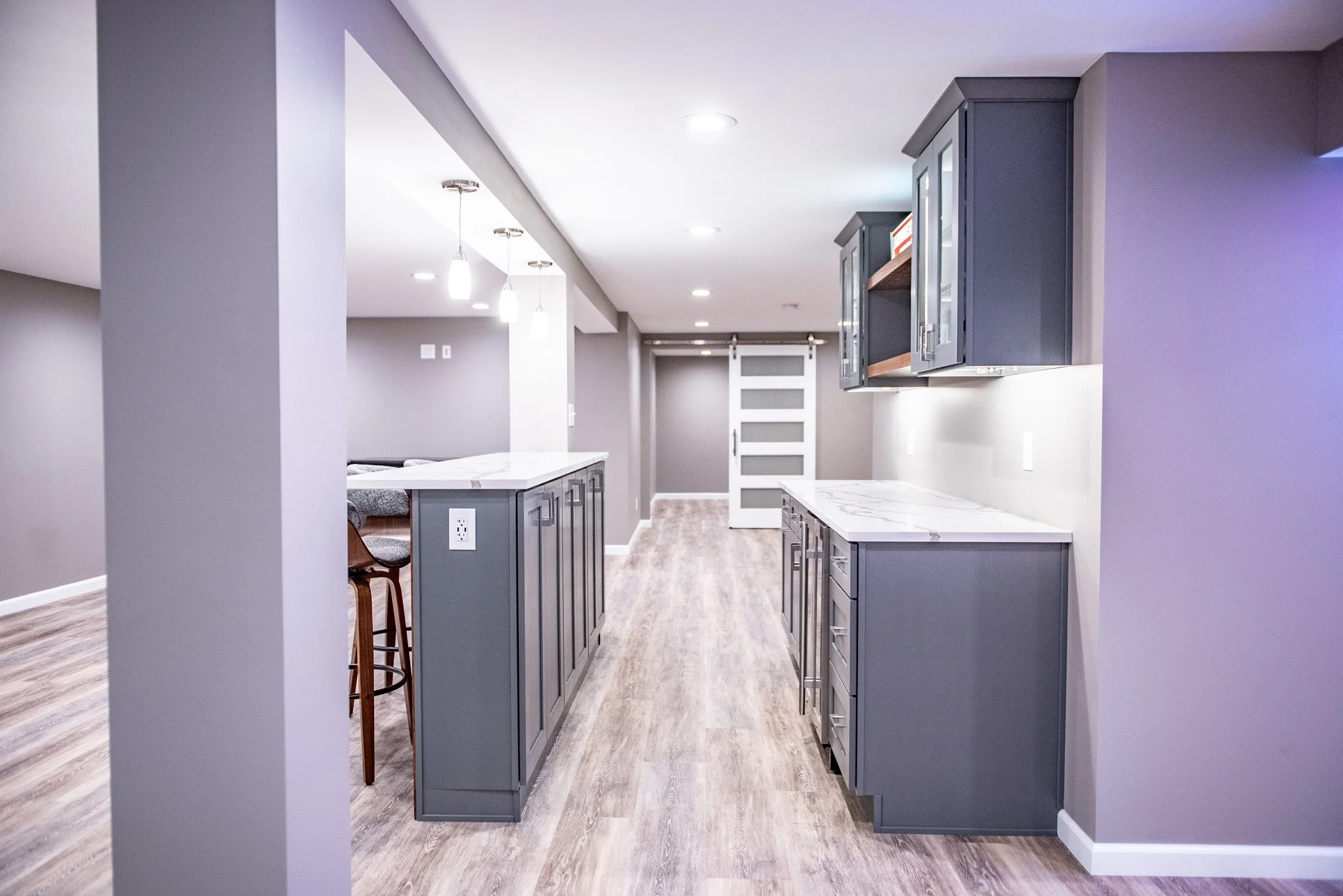 Gray cabinetry along an open basement bar
