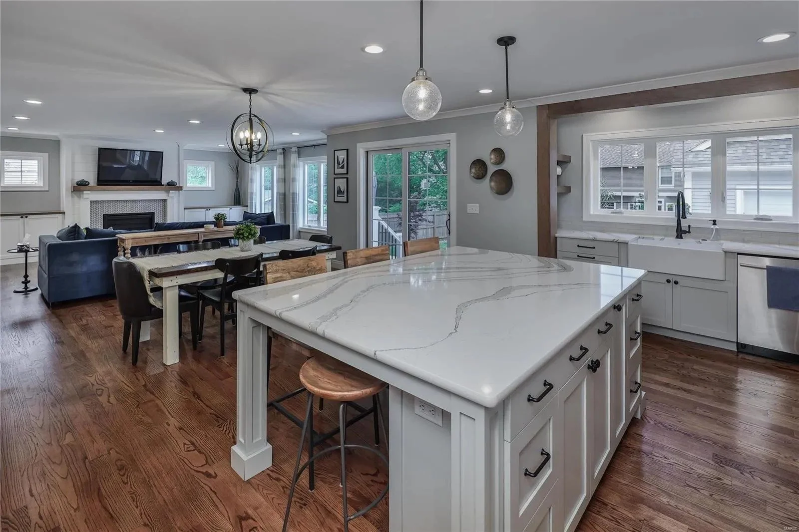 Open kitchen with a white quartz island and pendant lights