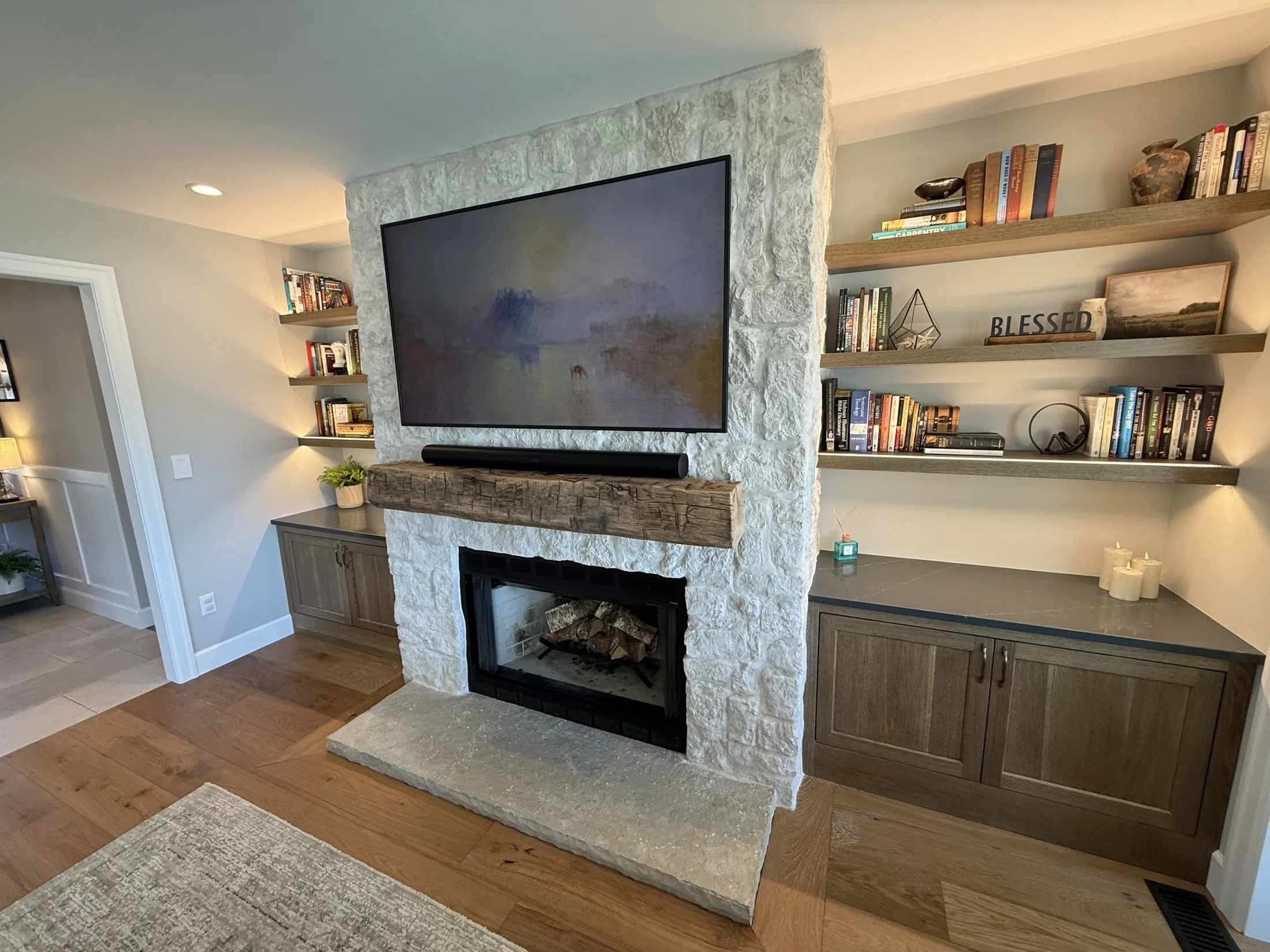 Floating shelves and lower cabinets beside the fireplace