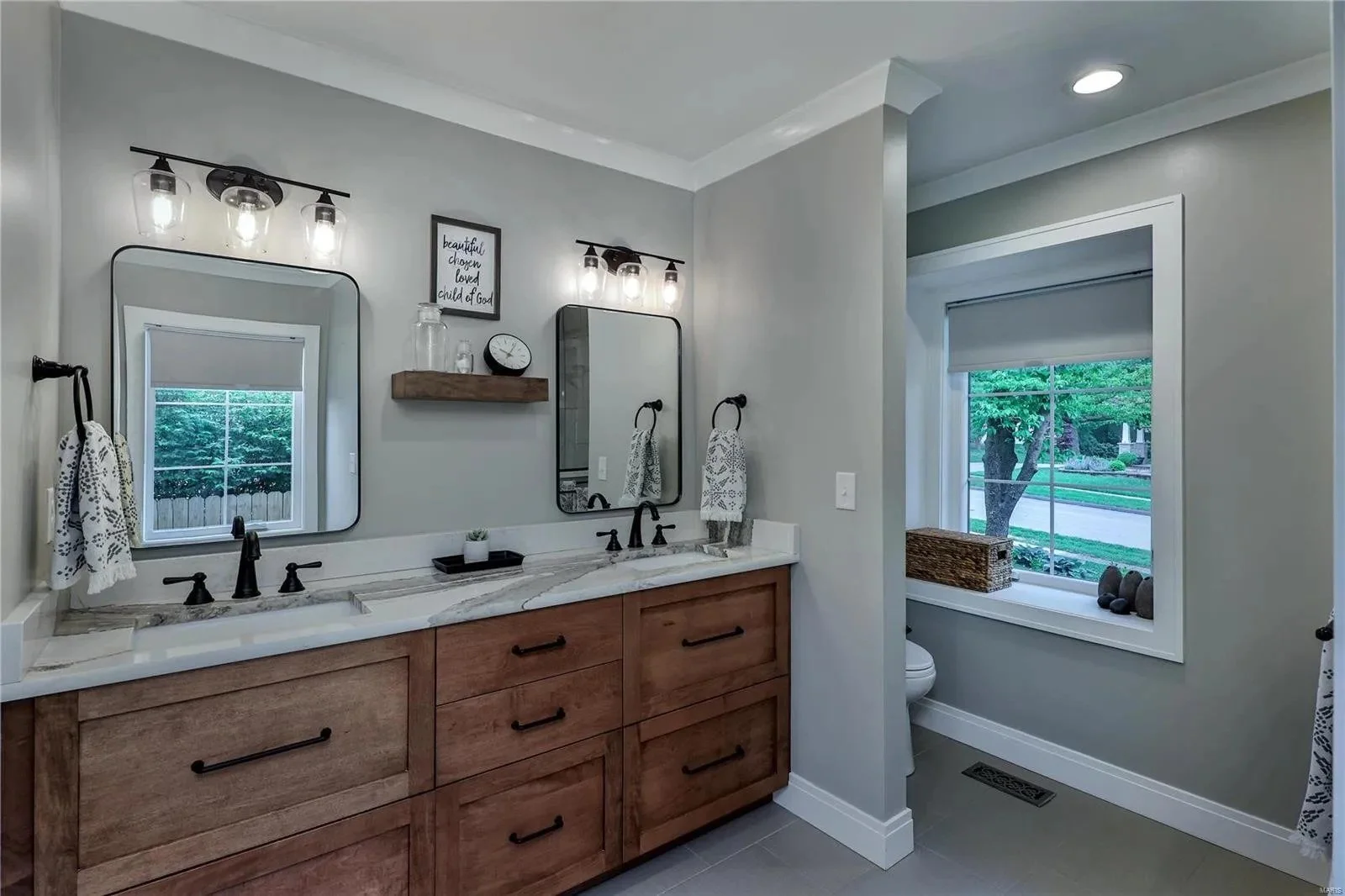 Bathroom with a wood vanity and twin mirrors