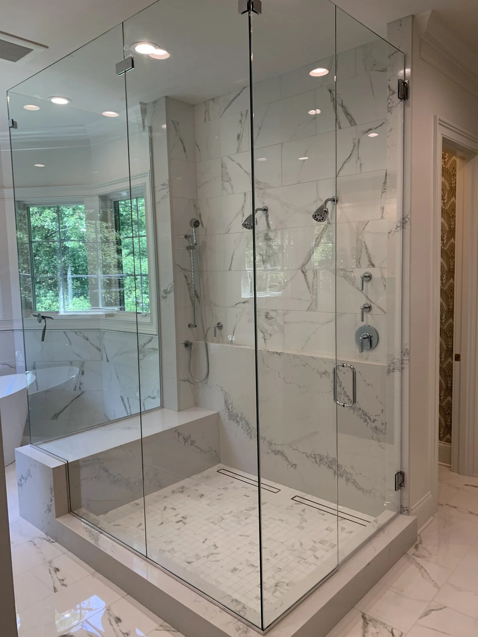 Frameless glass shower with a tile bench