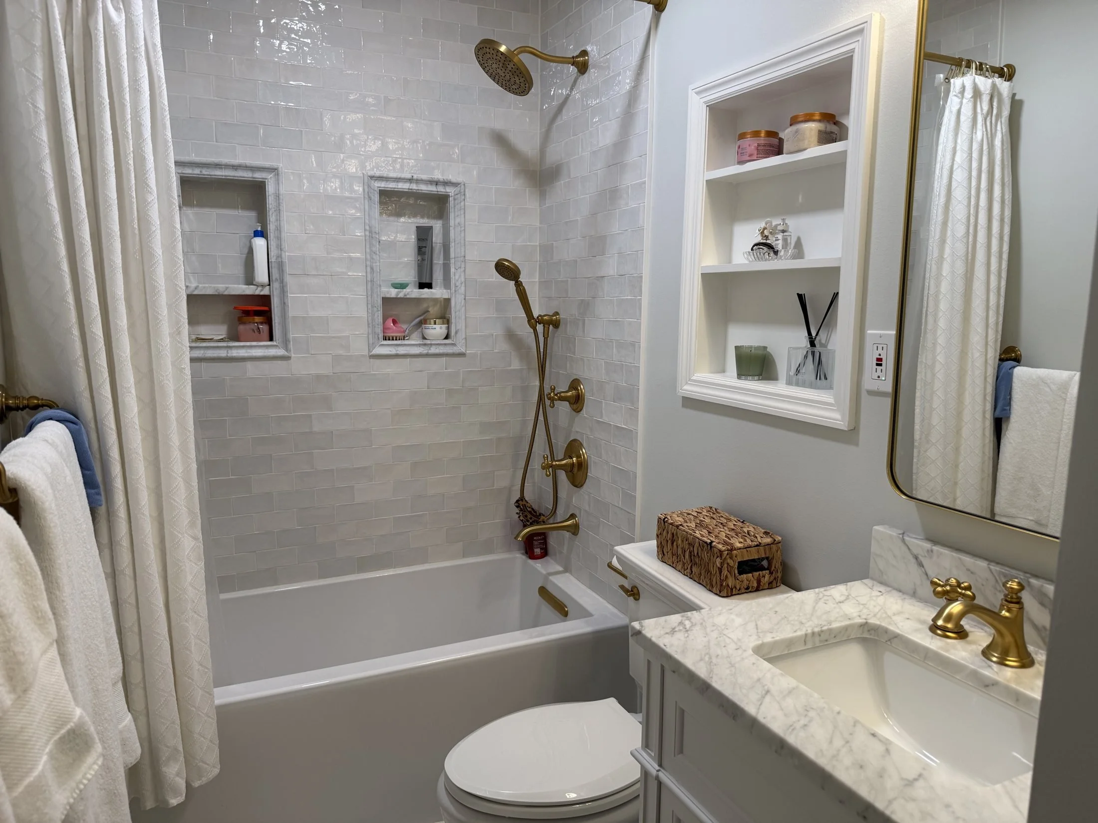 Tub surround with built-in niches and brass fixtures