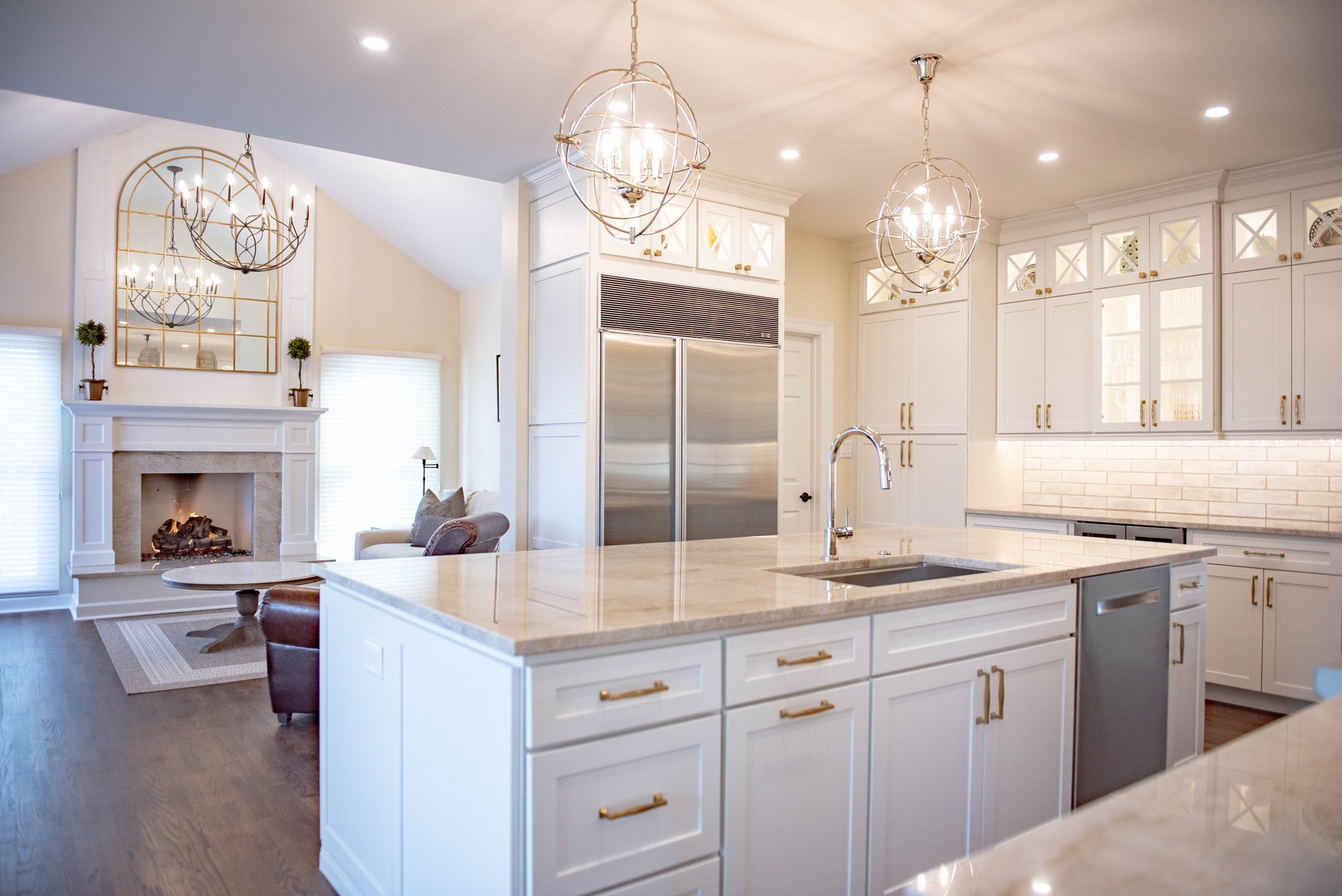 Quartz island and white cabinetry with a stainless refrigerator