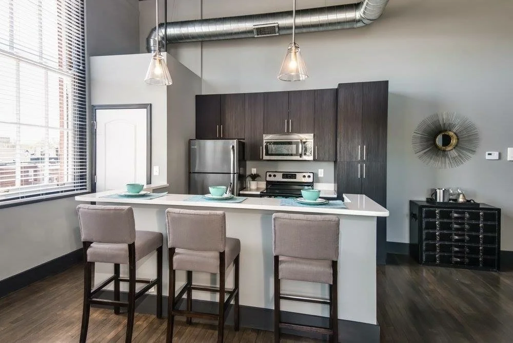 Loft kitchen with dark cabinetry and pendants