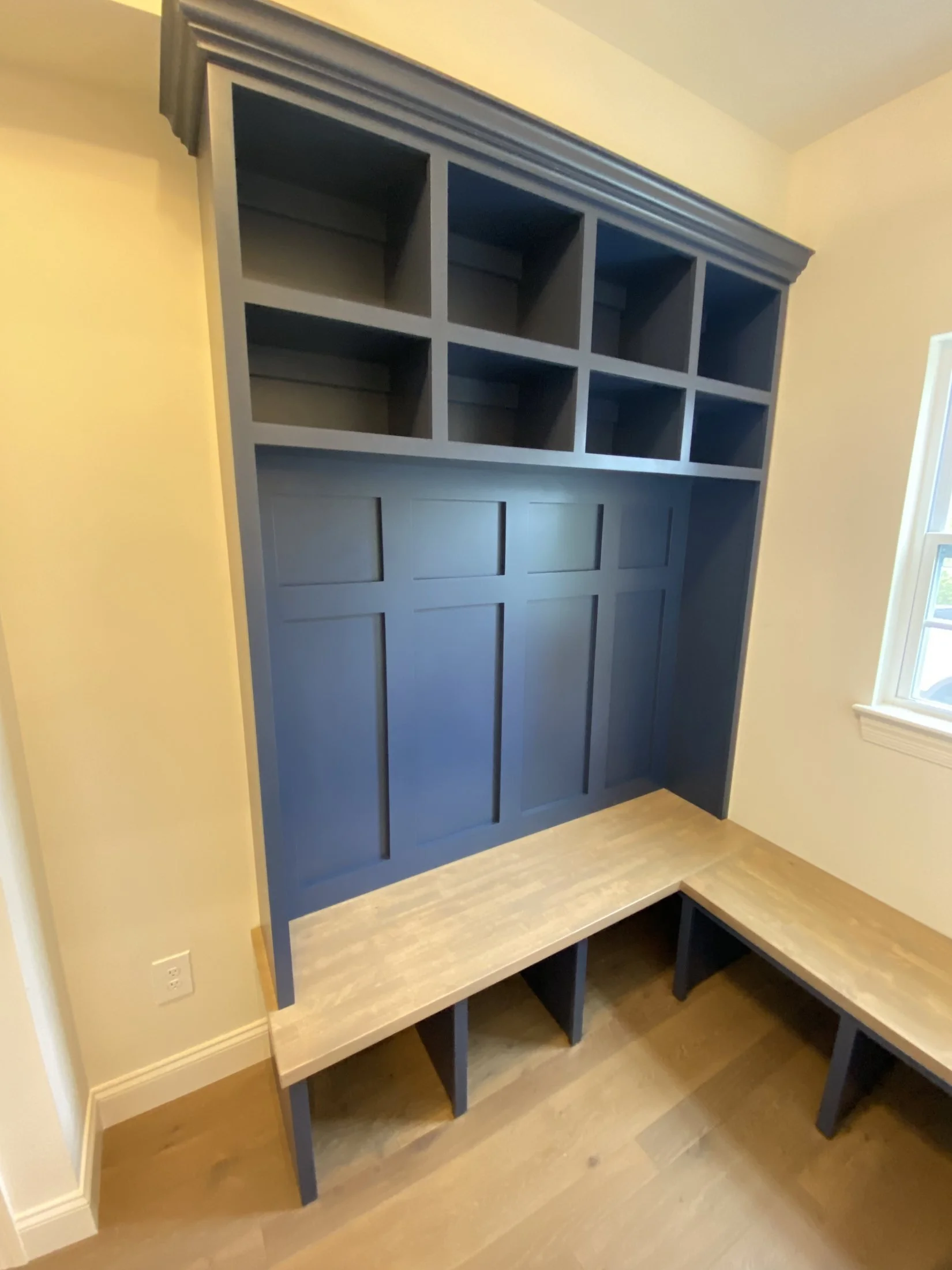 Navy mudroom built-in beside a window