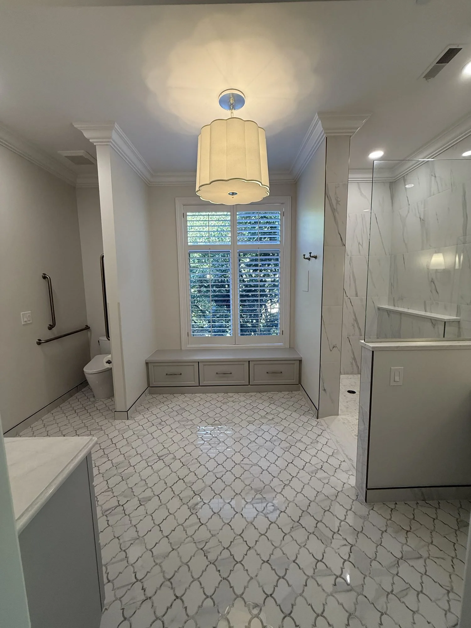 Primary bathroom window bench with arabesque marble floor tile
