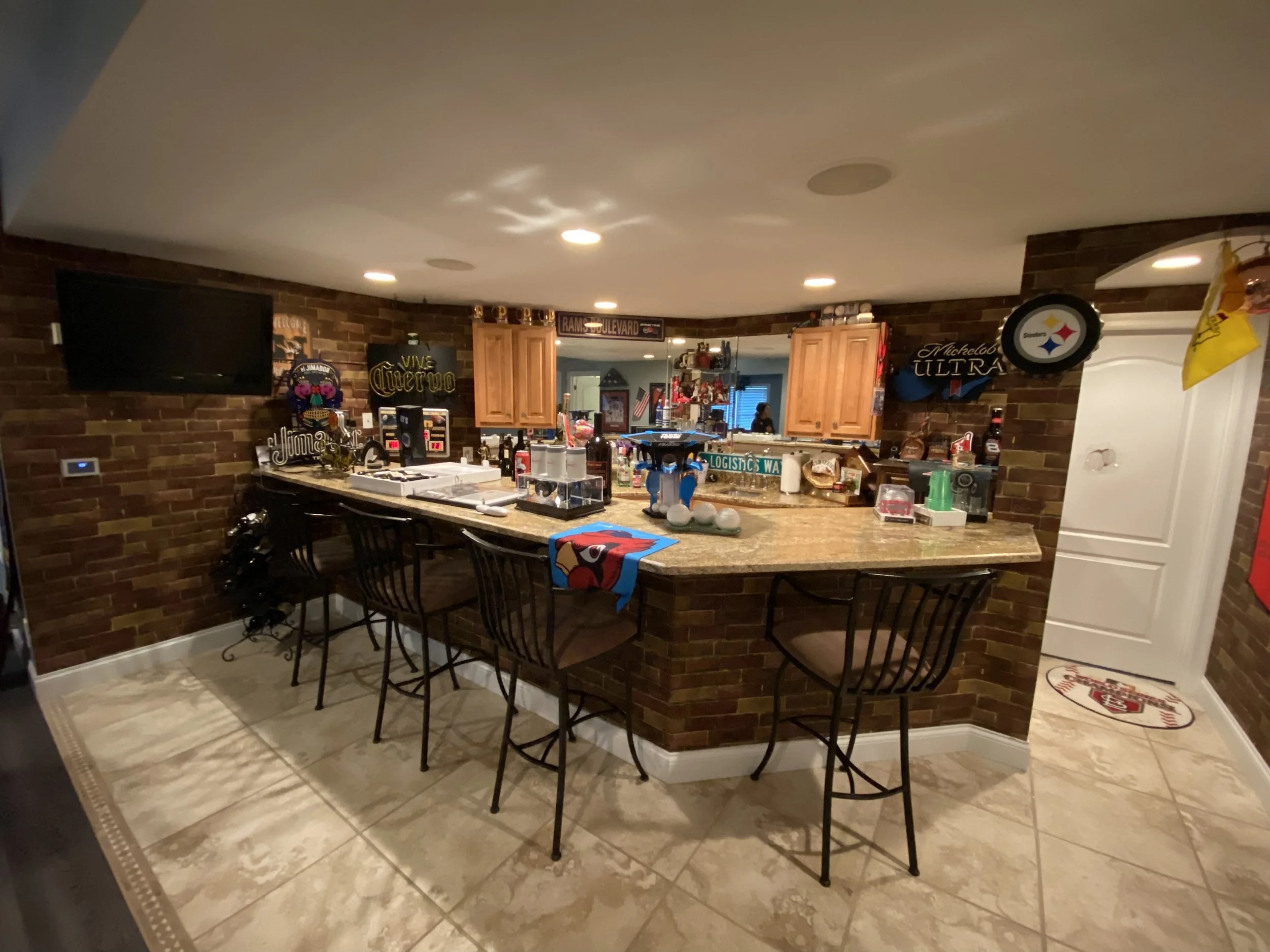 Basement bar with oak cabinets and faux brick before the remodel