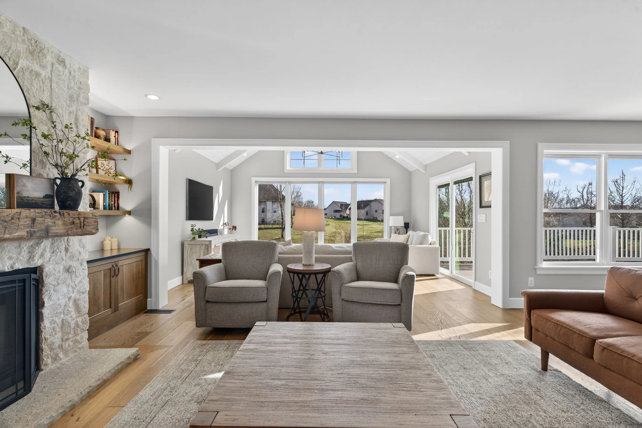 Stone fireplace wall with open shelving and wood cabinets