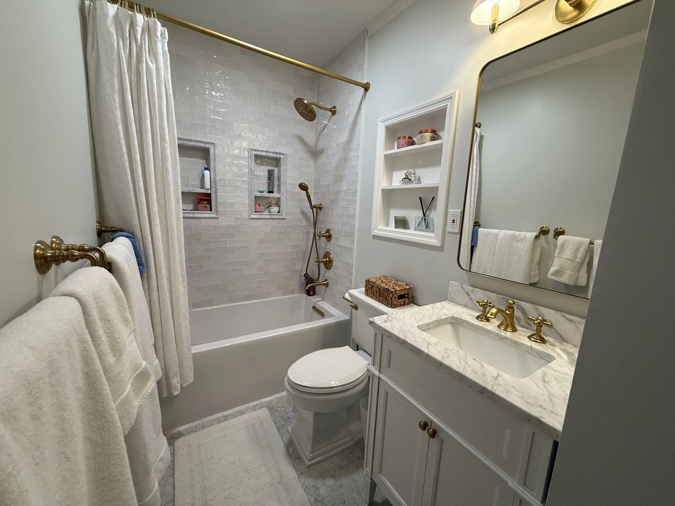 Guest bath with a white vanity and brass hardware