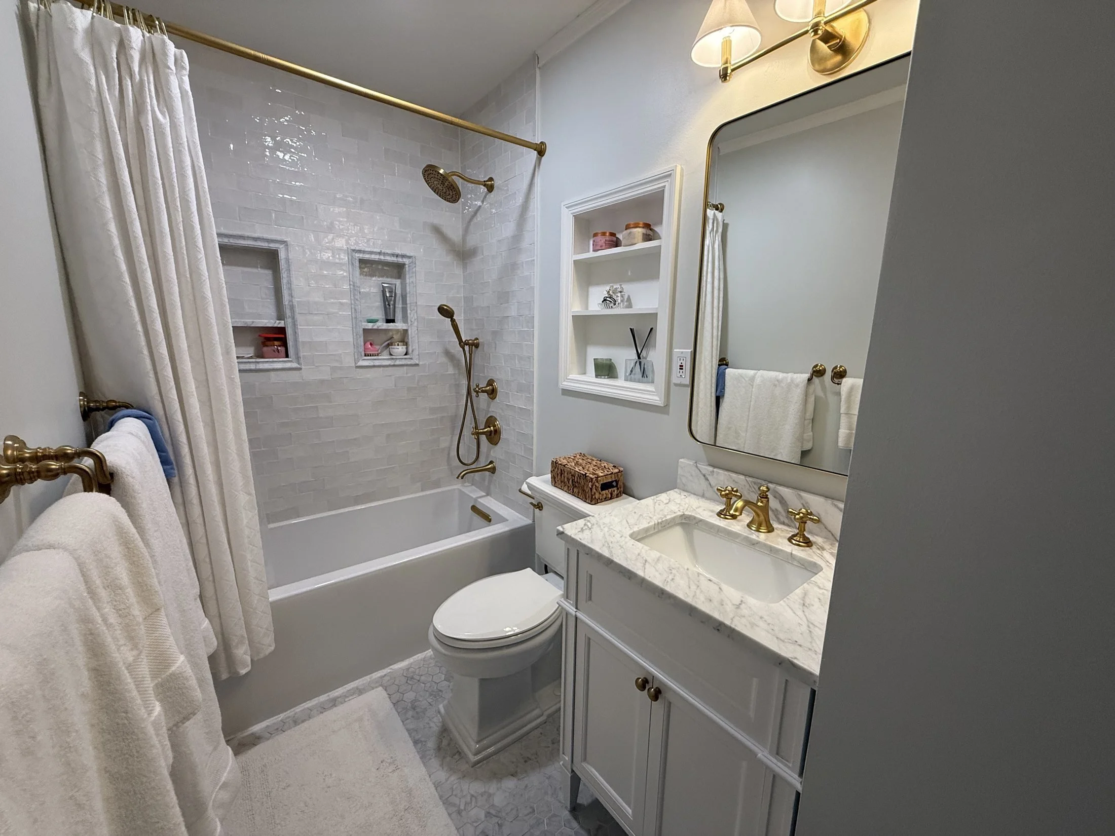 Guest bath with a tub, vanity, and recessed shelf