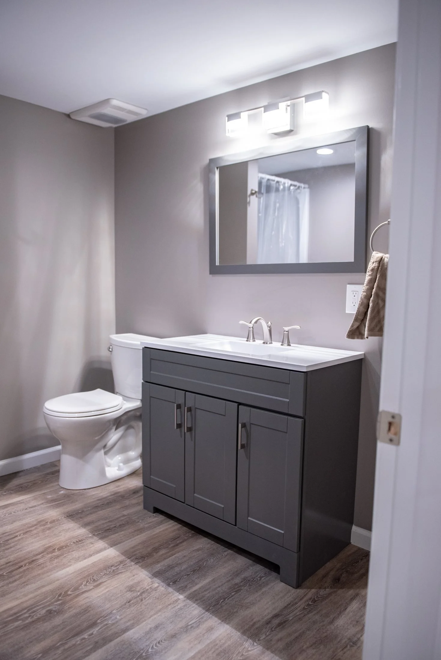 Basement bathroom with a gray vanity