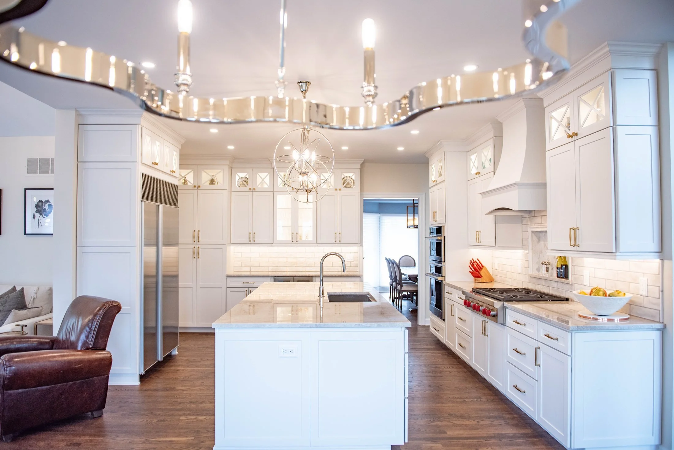 Wide view of a white kitchen with a long quartz island