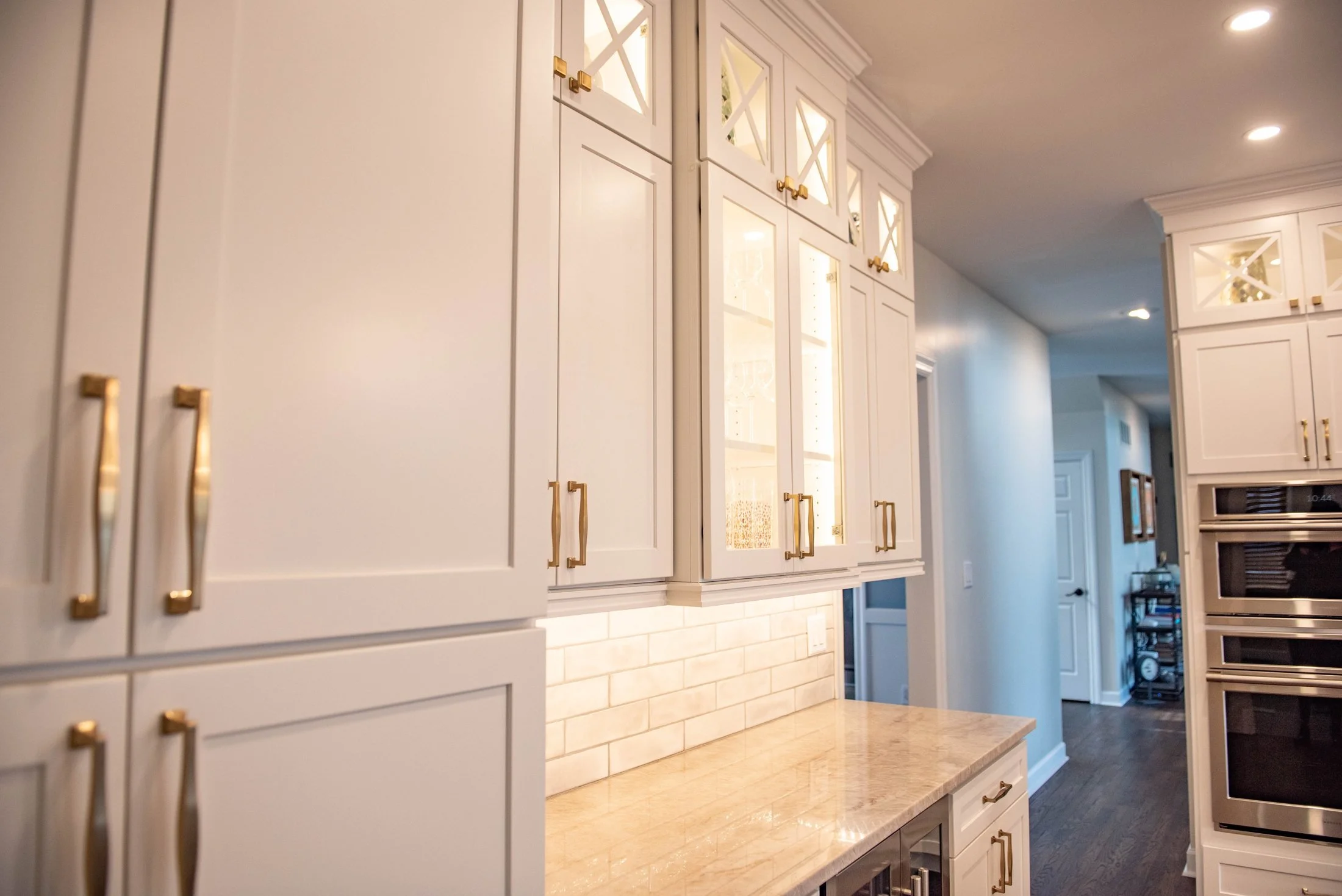 Tall white cabinetry with brass pulls