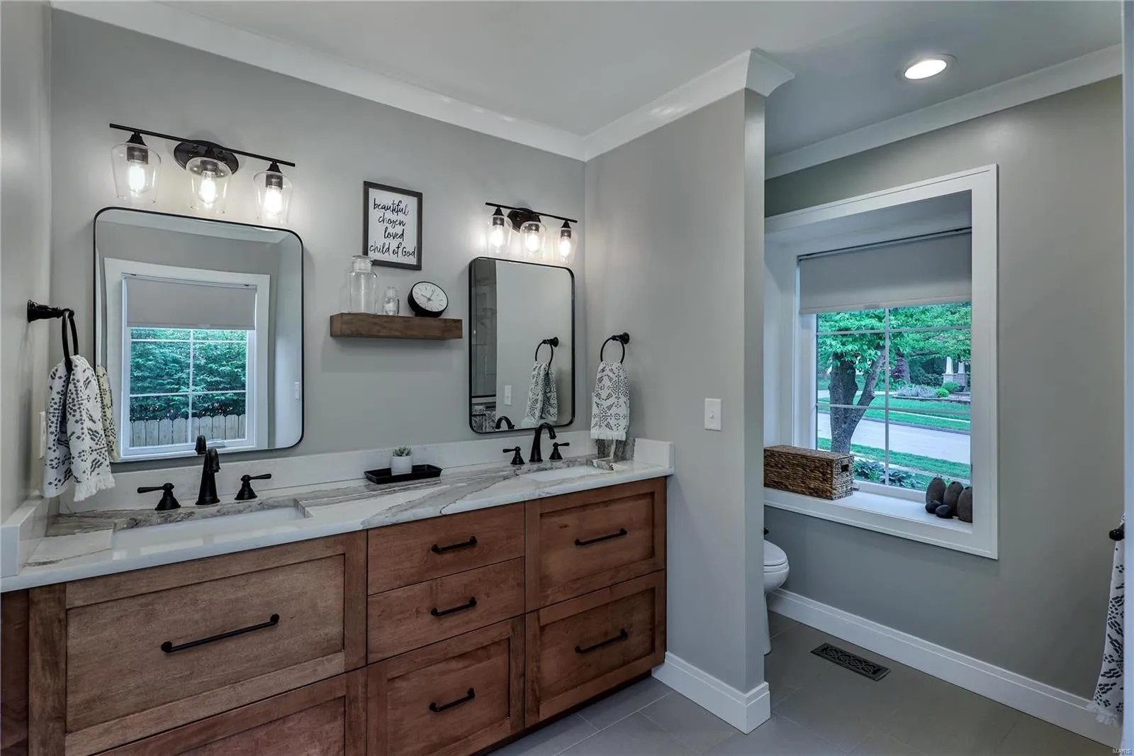 Bathroom with a wood vanity and twin mirrors