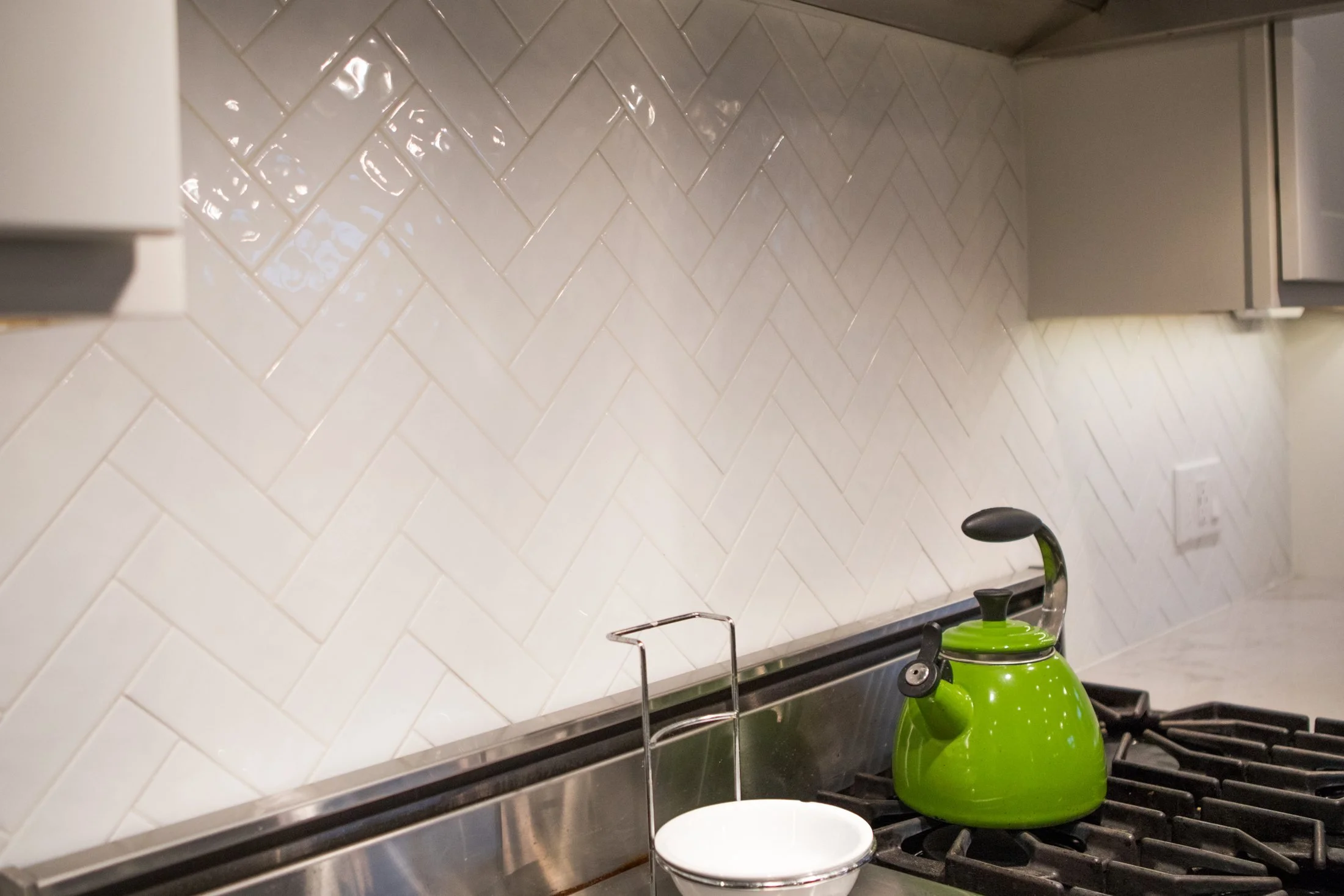Herringbone tile backsplash behind the range