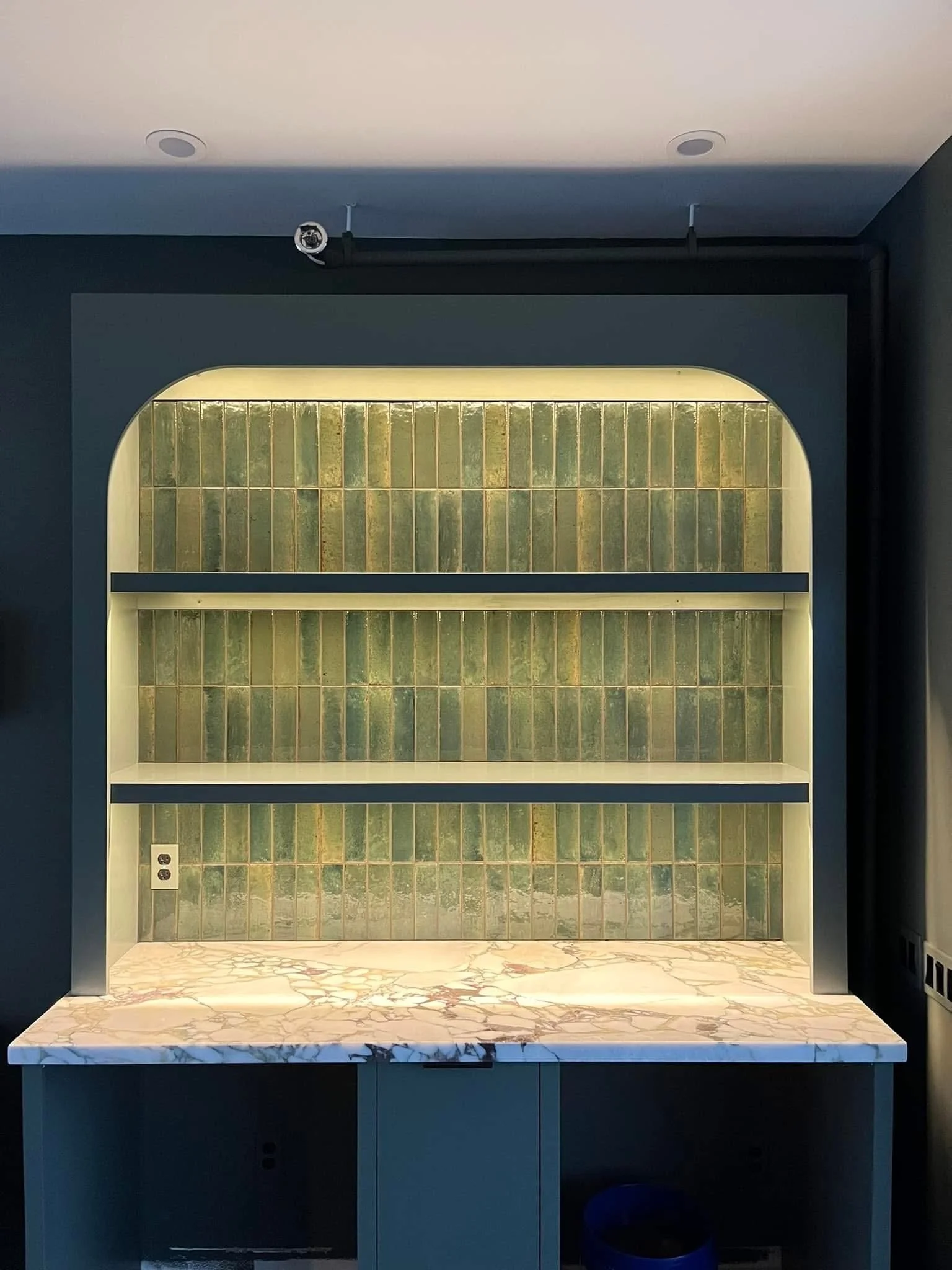 Arched built-in bookcase with lit shelving