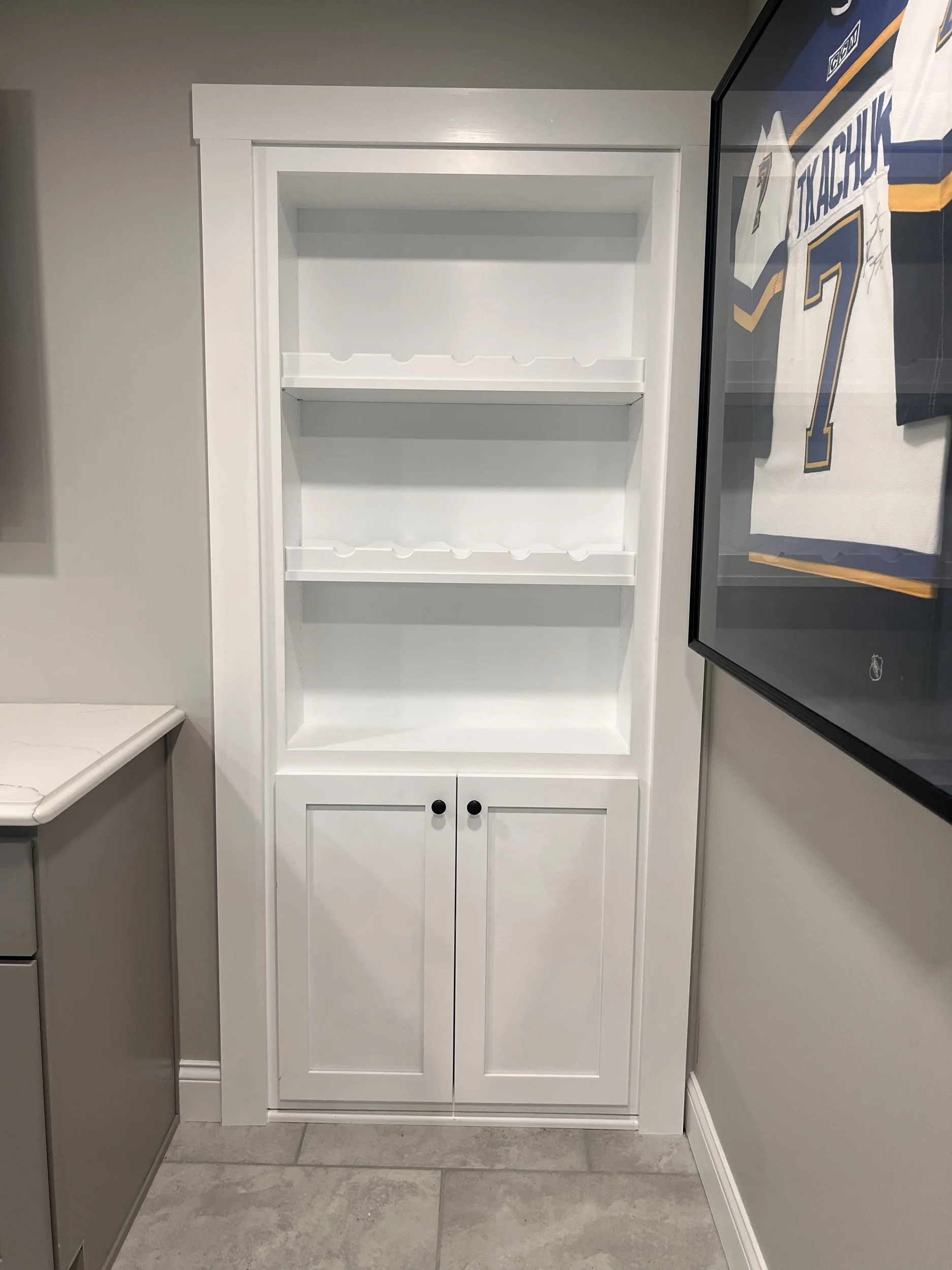 White bookcase Murphy door closed beside the bar