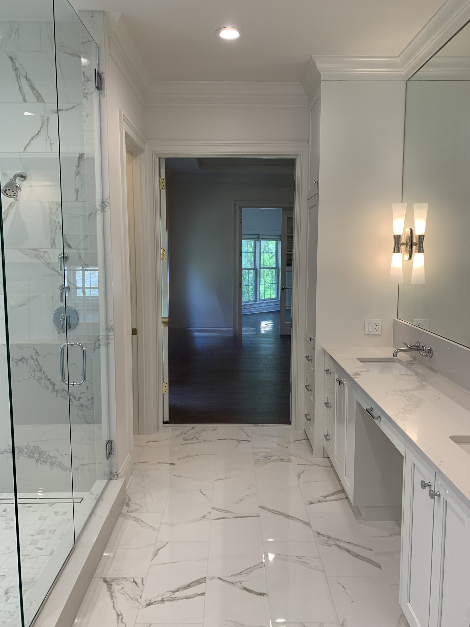 Primary bath with a glass shower and vanity wall