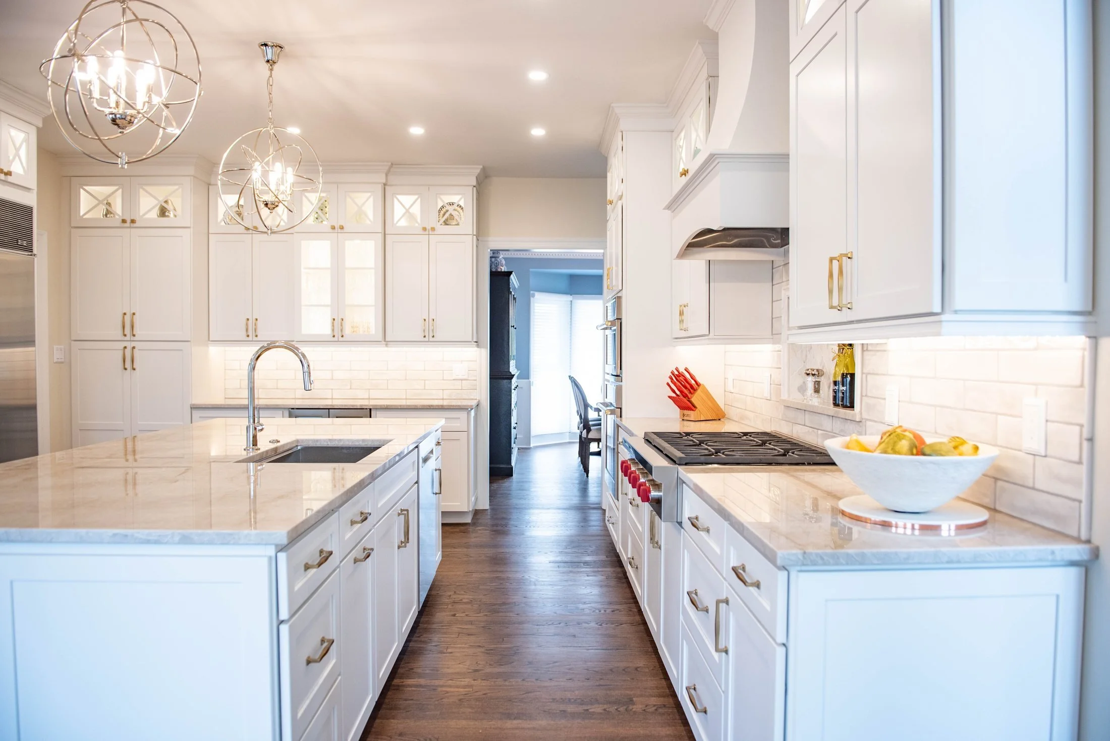 White kitchen with a range wall and quartz island