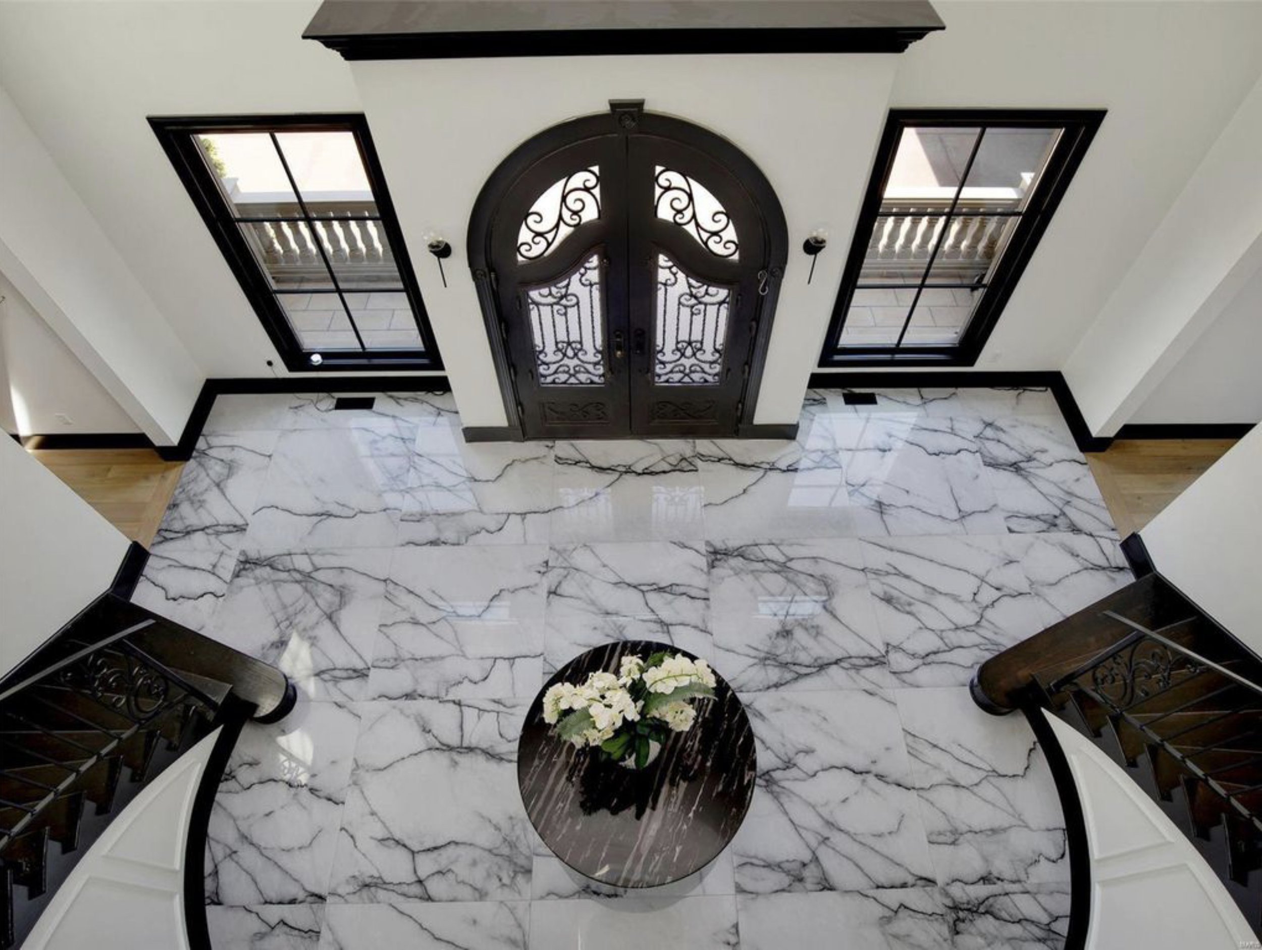 Grand foyer with a double curved staircase and marble floor