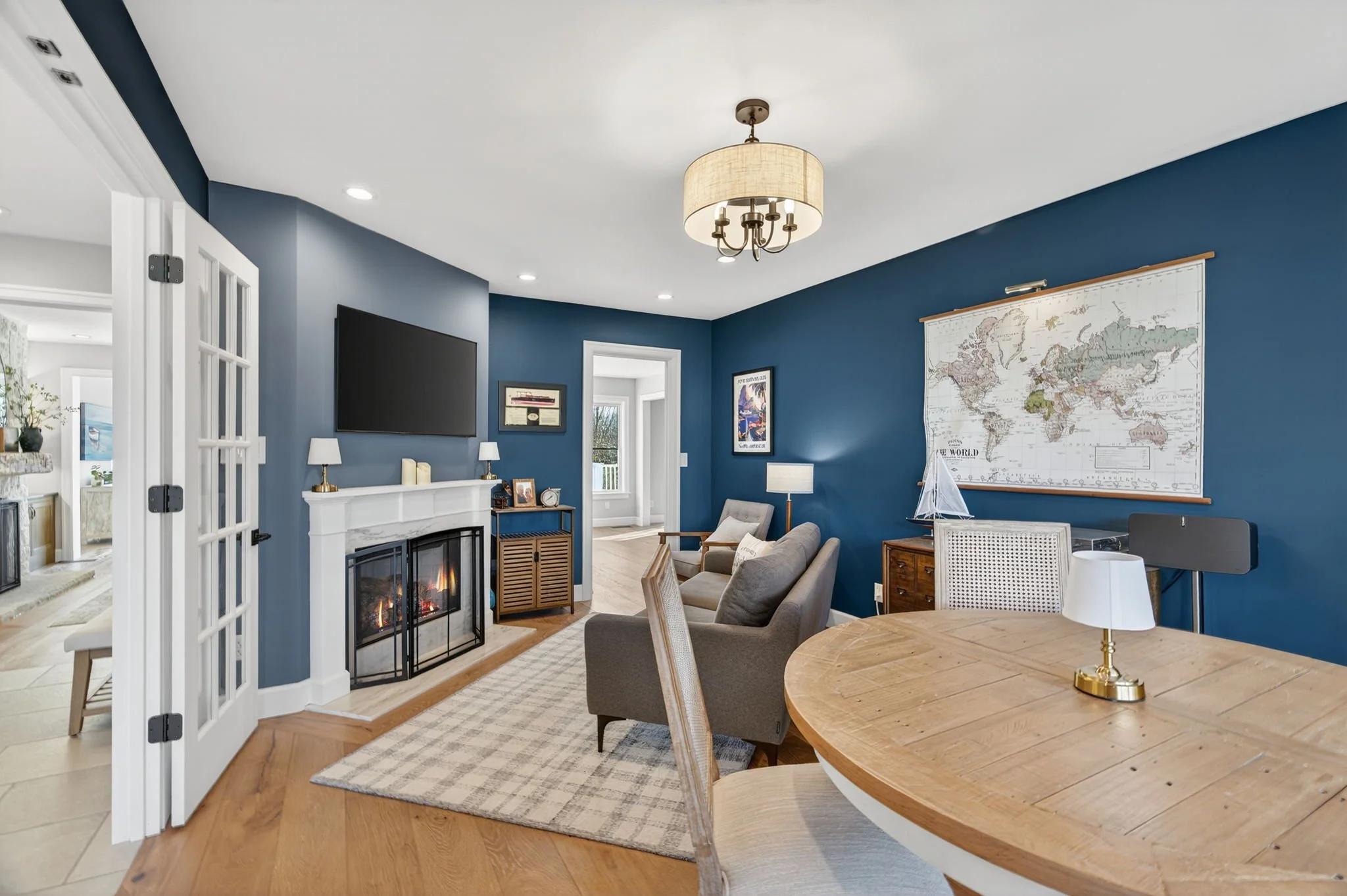 Navy sitting room with a fireplace and French doors