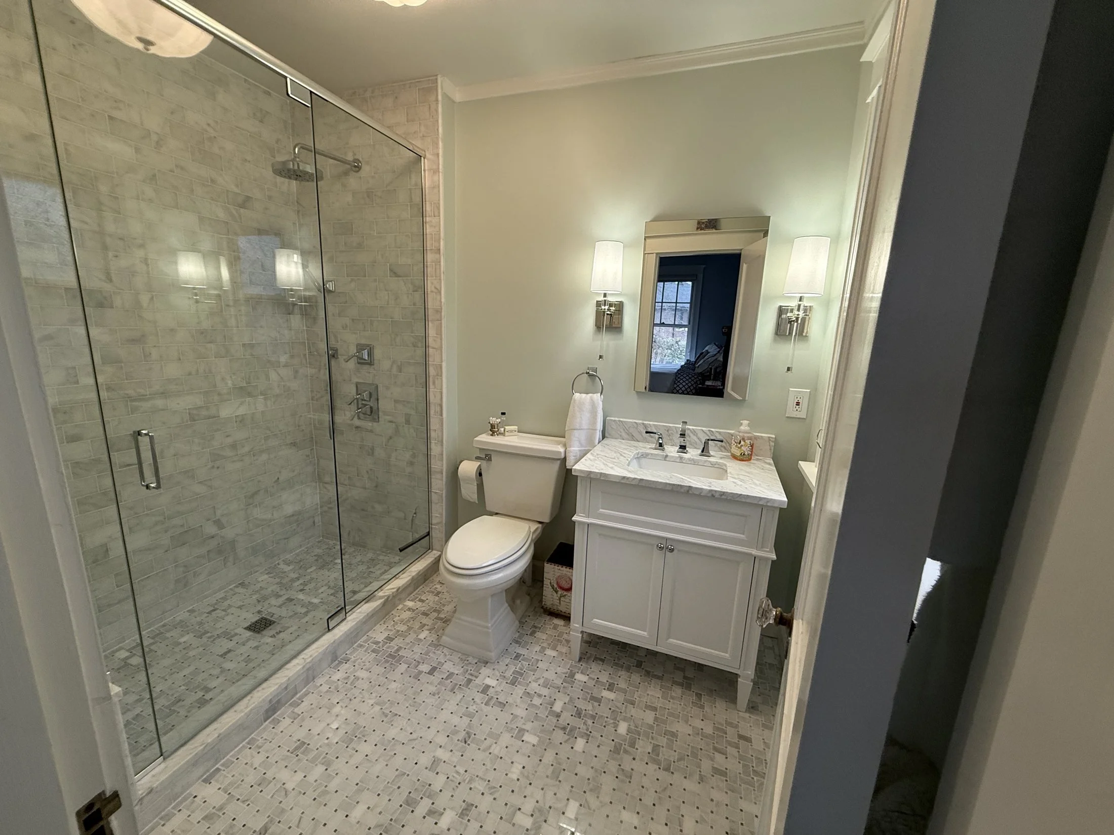 Bath with a glass shower and white vanity