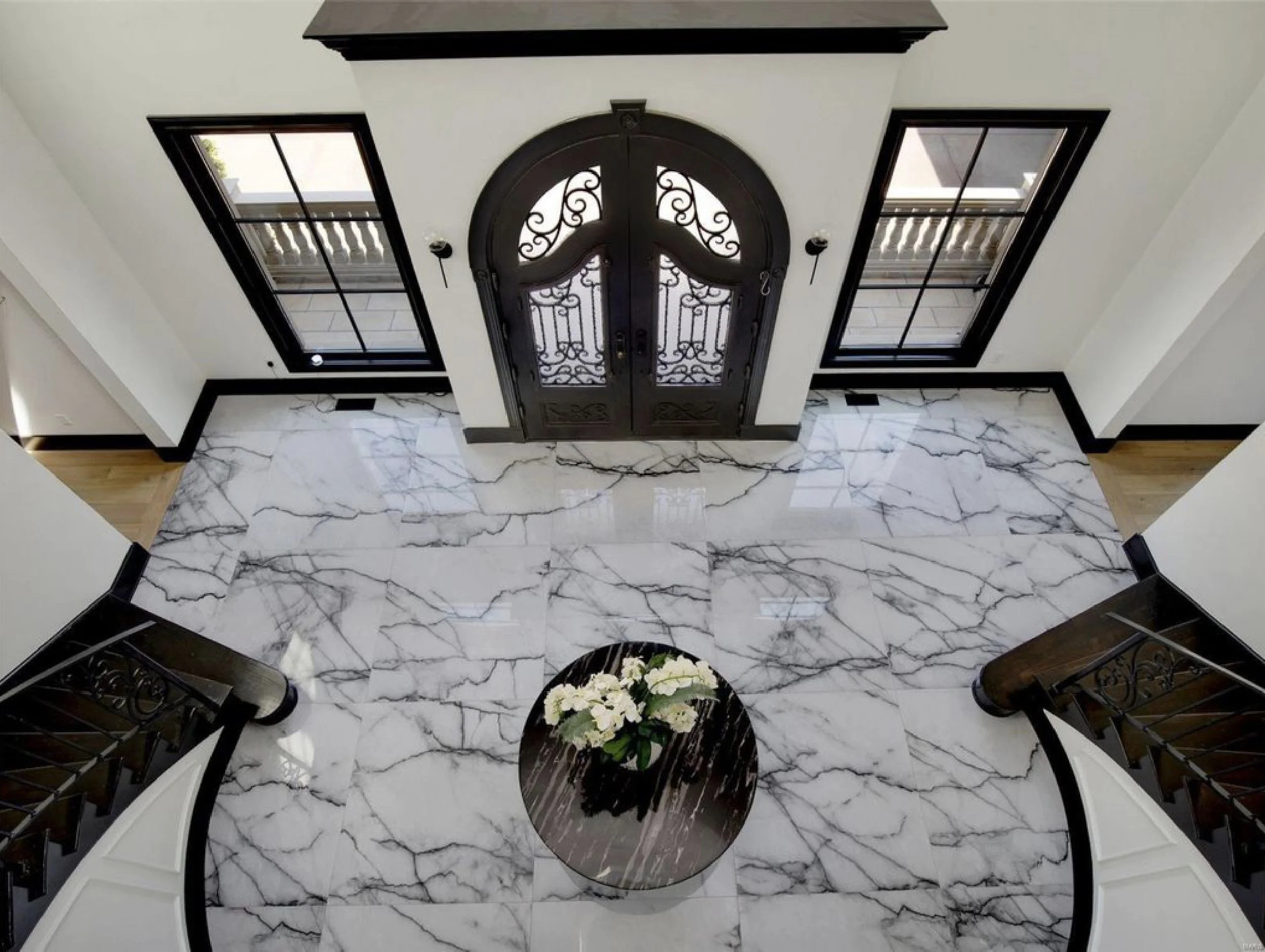 Grand foyer with a double curved staircase and marble floor