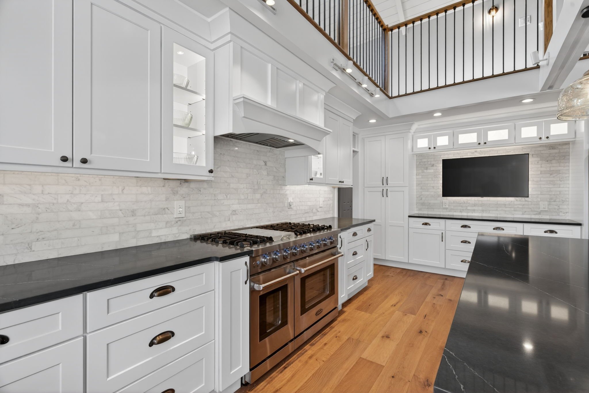 Double range with white cabinetry and a TV niche