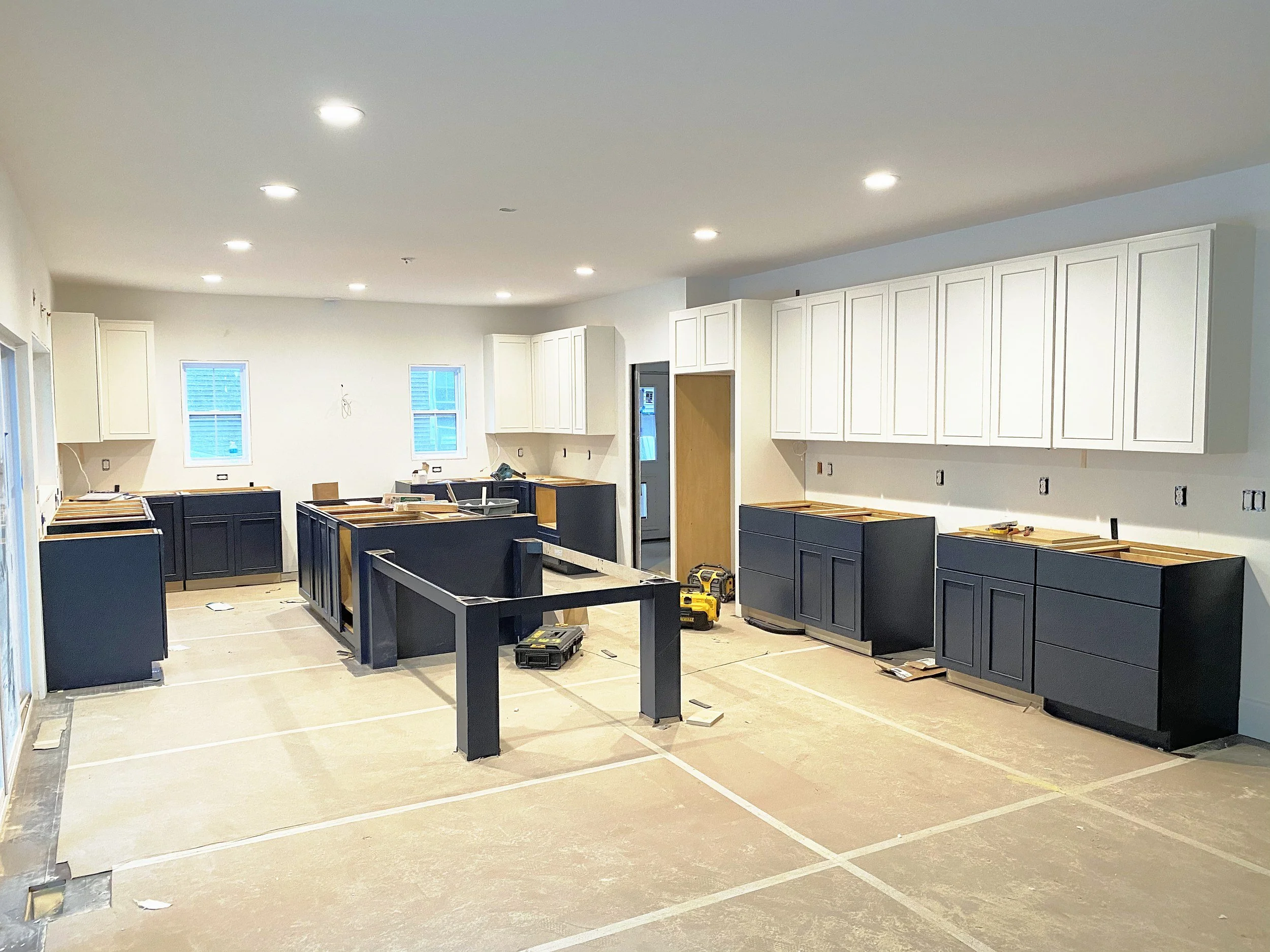 Navy base cabinets and white uppers set before countertops