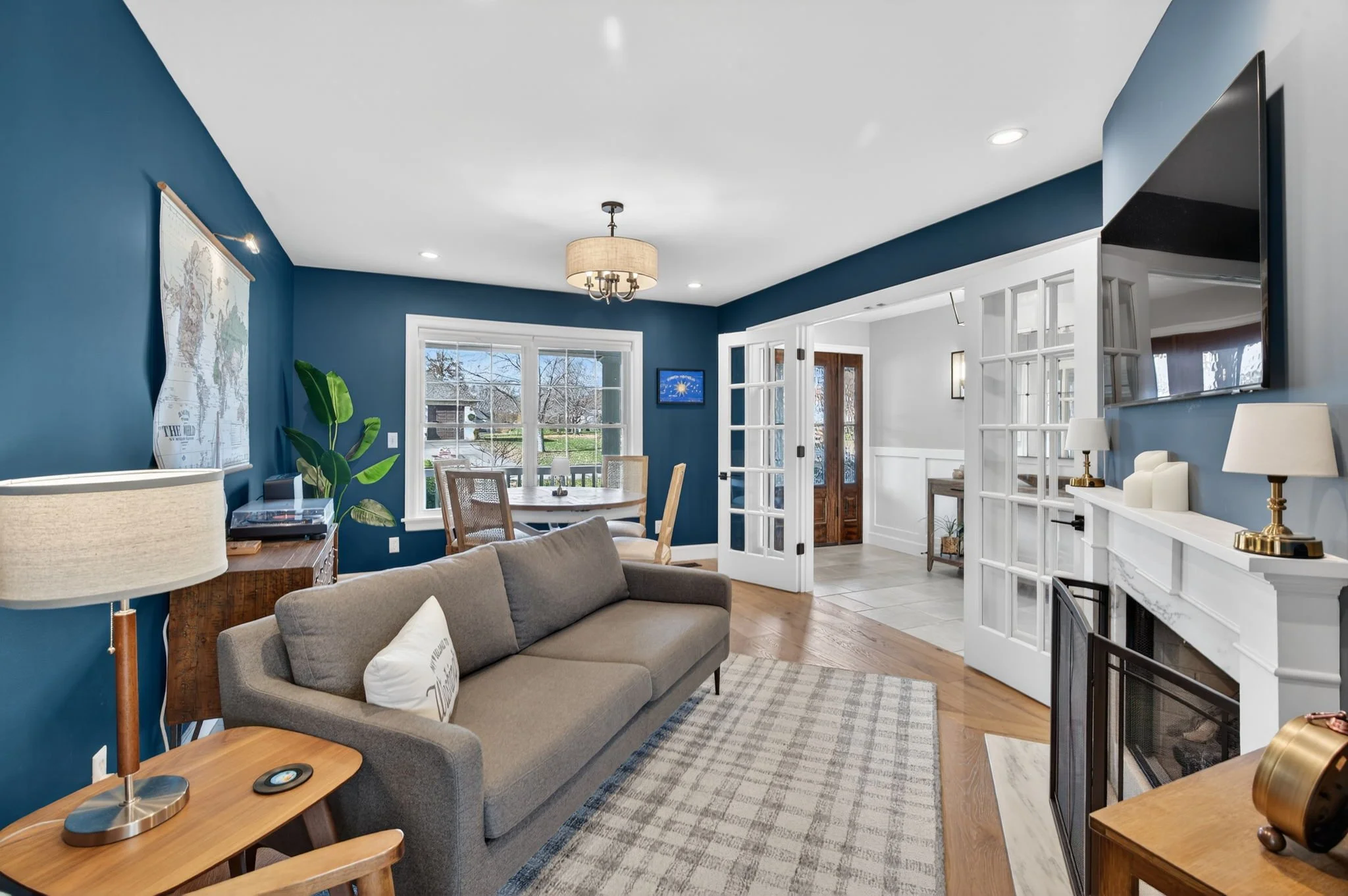 Navy den with a white fireplace surround