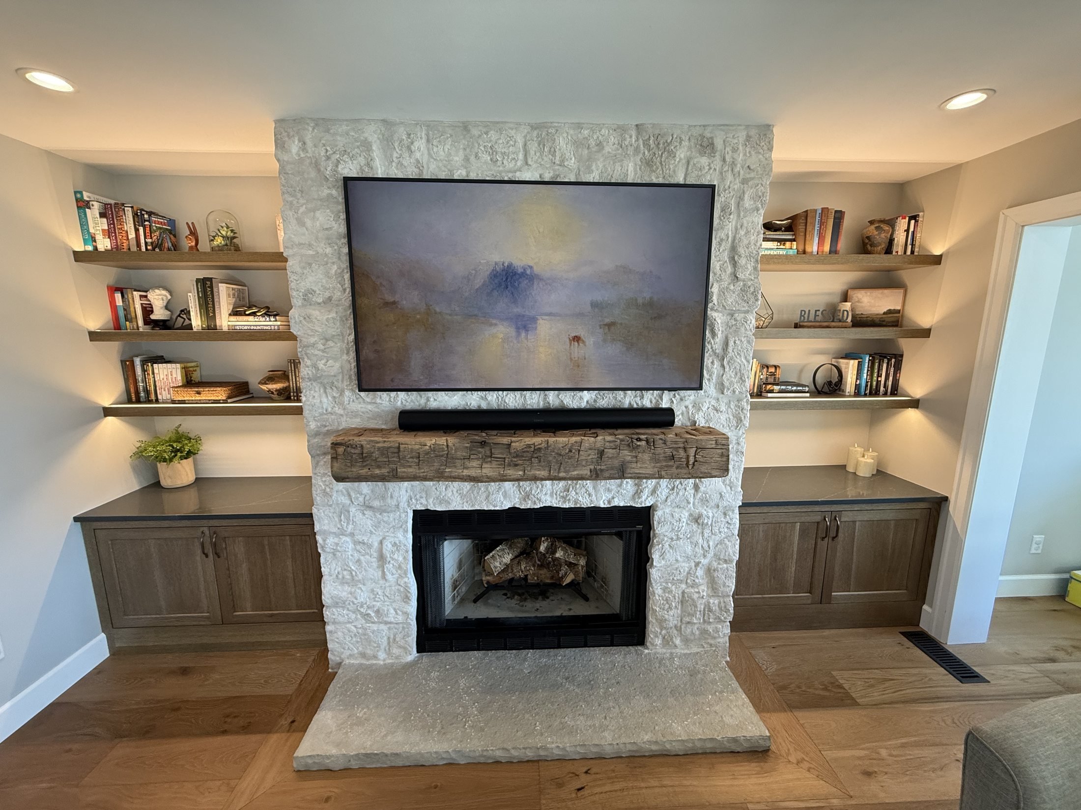 Stone fireplace with a beam mantel and built-in cabinets