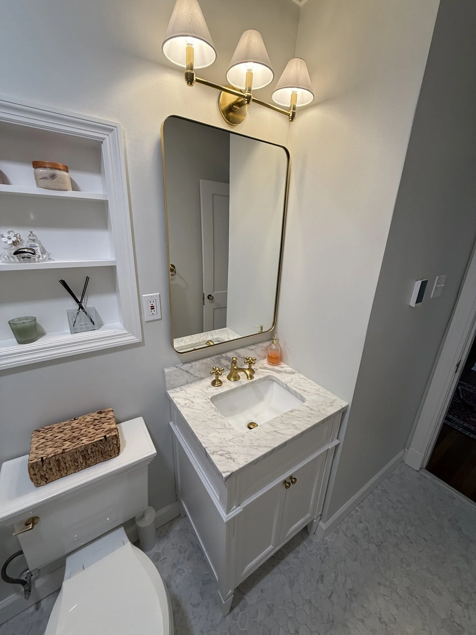Vanity with a brass faucet and arched mirror