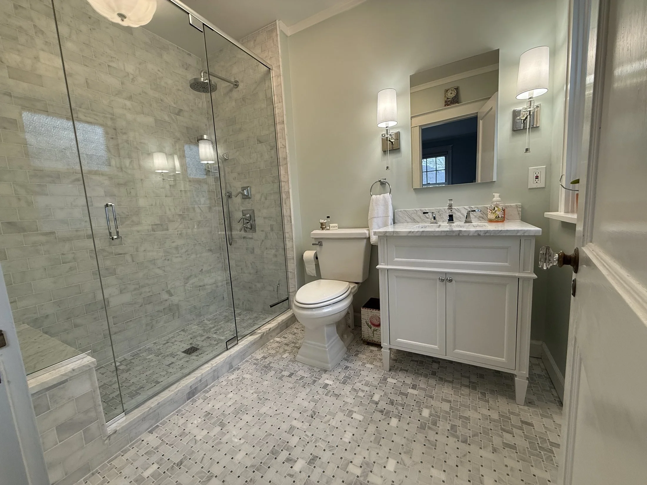 Marble walk-in shower with frameless glass