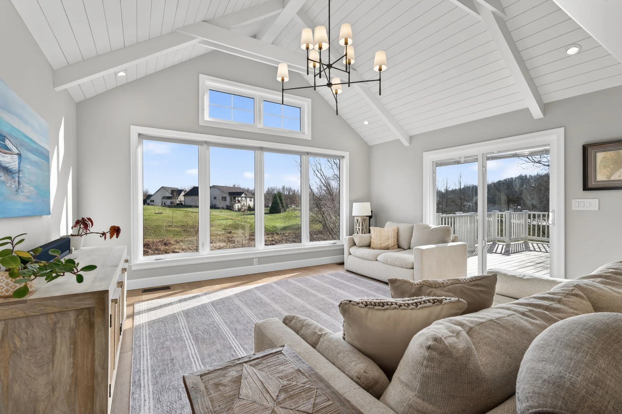 Great room with a vaulted shiplap ceiling and walls of windows