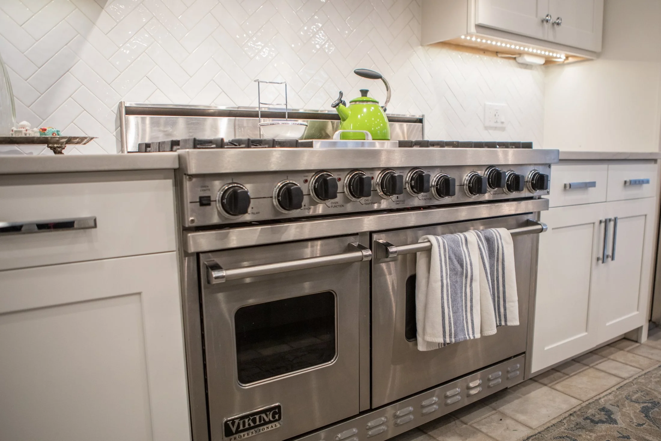 Professional gas range set into white cabinetry
