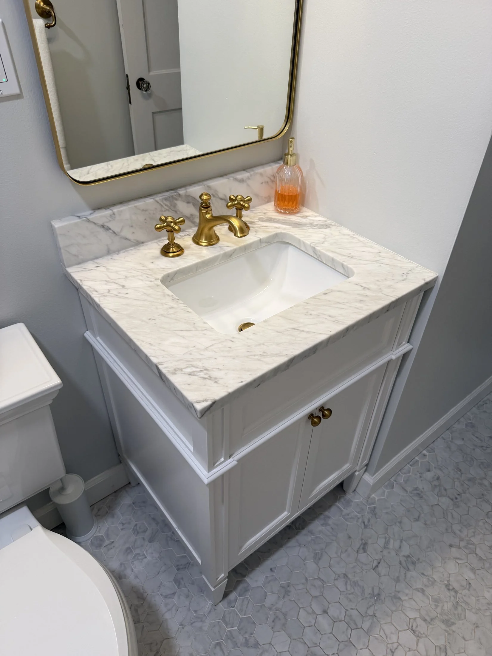 White vanity with a marble-look top