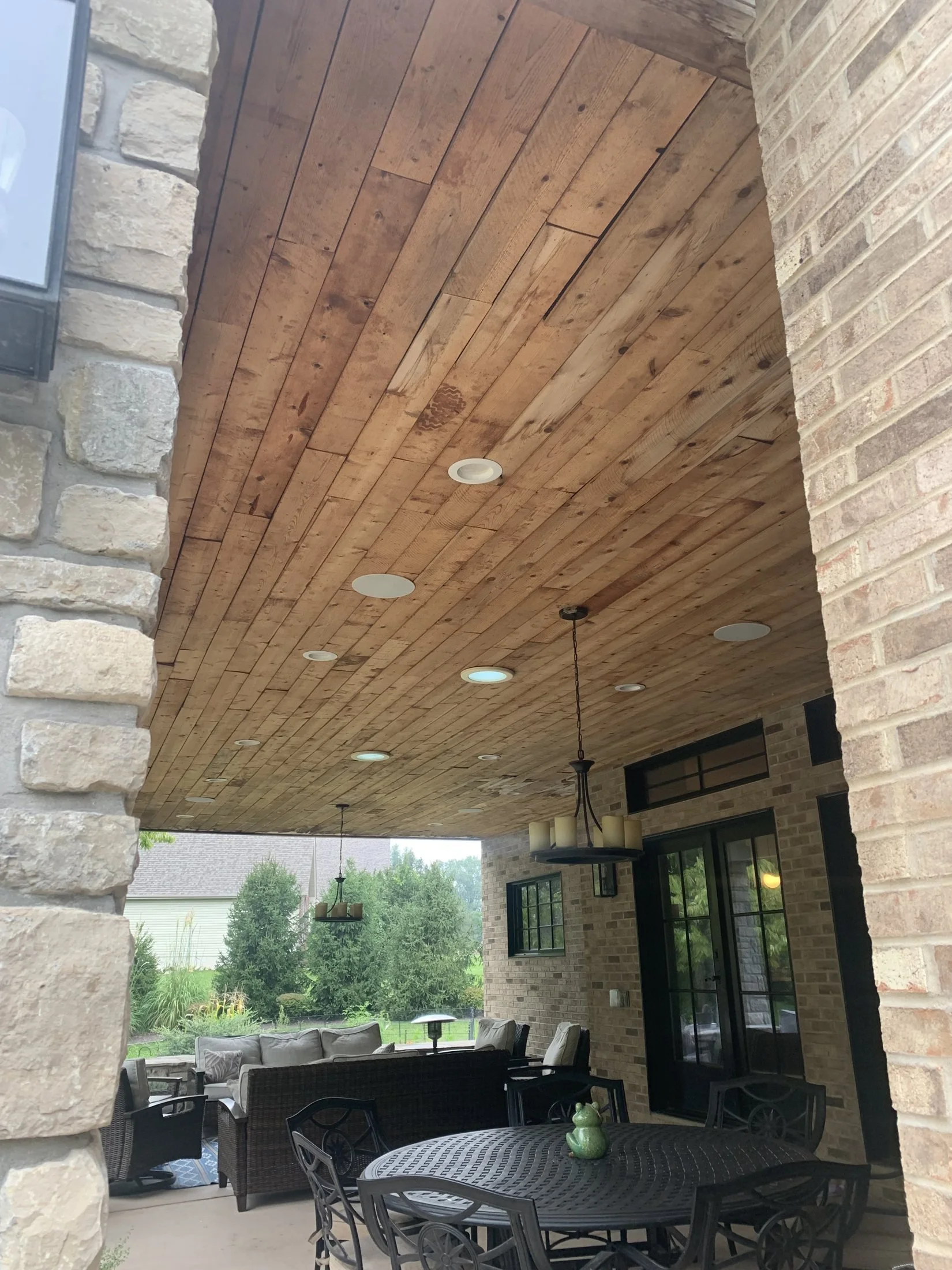 Covered patio with a wood ceiling and dining set