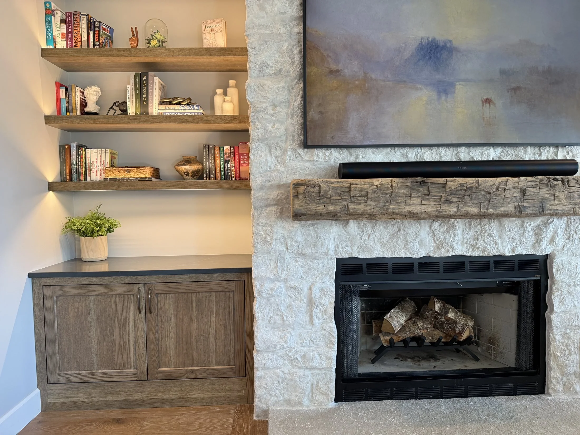 Built-in cabinetry beside a stone fireplace
