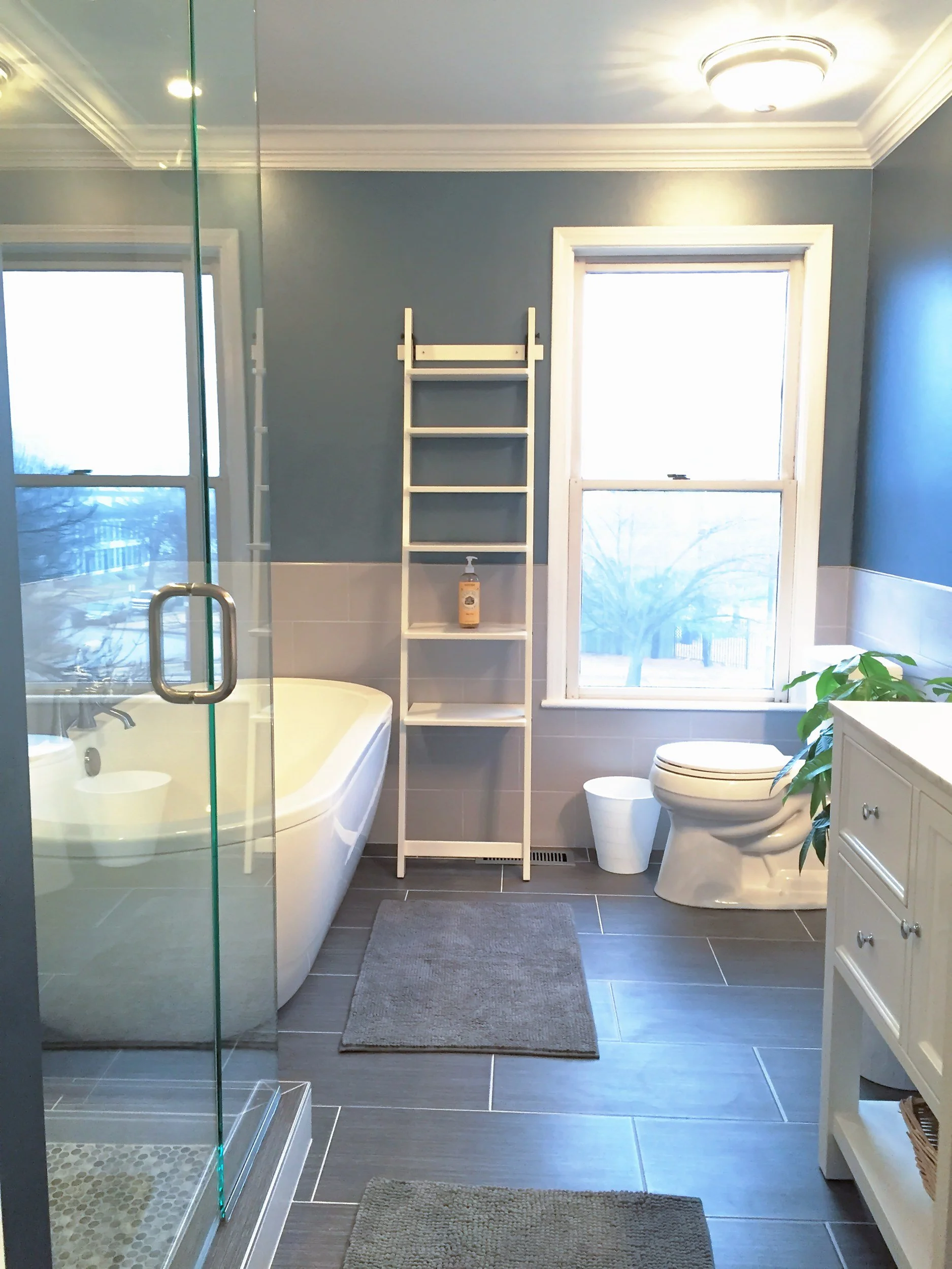 Primary bath with navy walls, a glass shower, and a freestanding tub