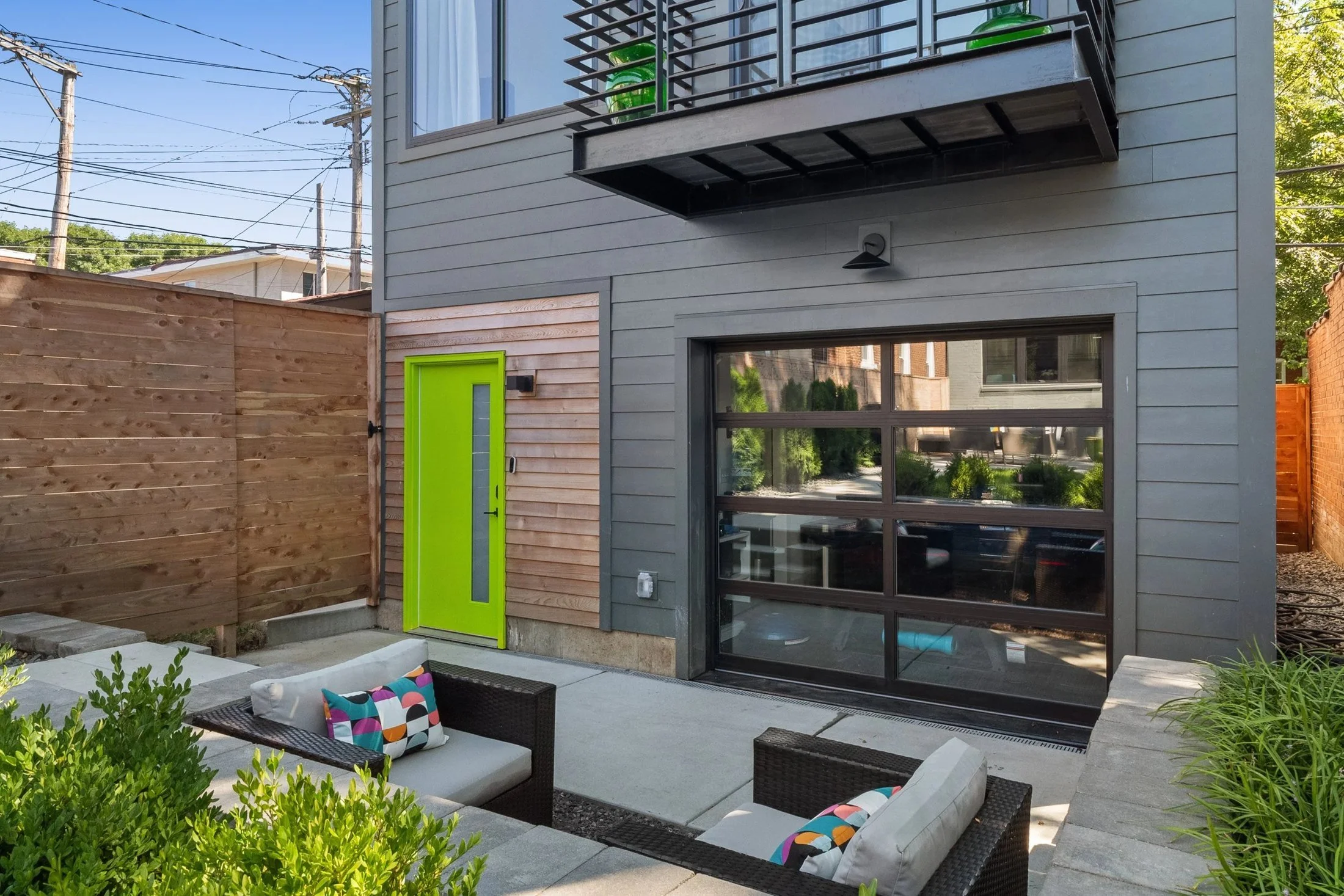 Backyard patio with lounge seating beside a glass garage door