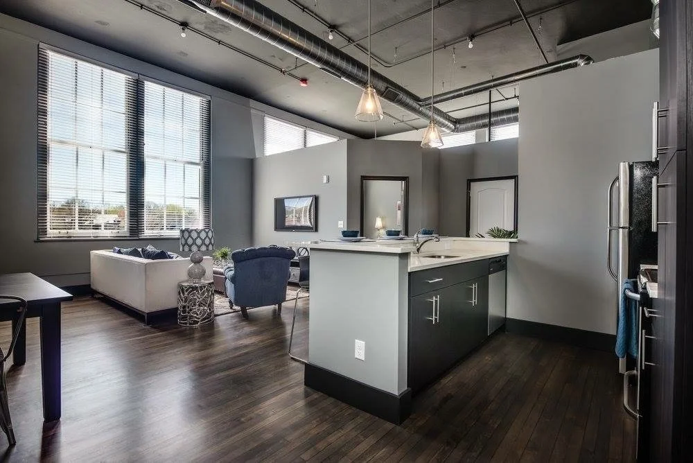Loft kitchen with dark cabinetry and large windows