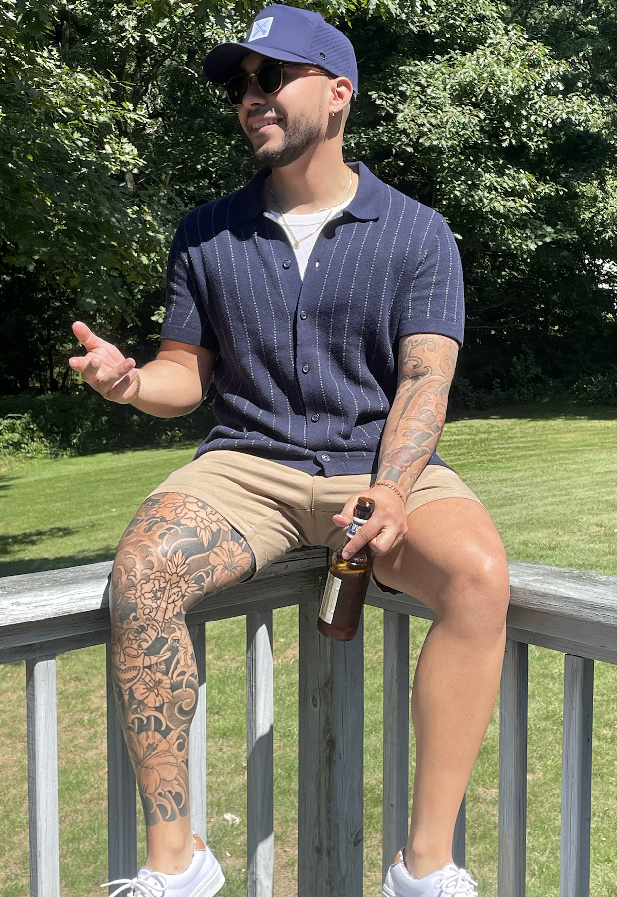 Personal trainer and nutrition coach Josh Diaz sitting on a railing, holding a beer.