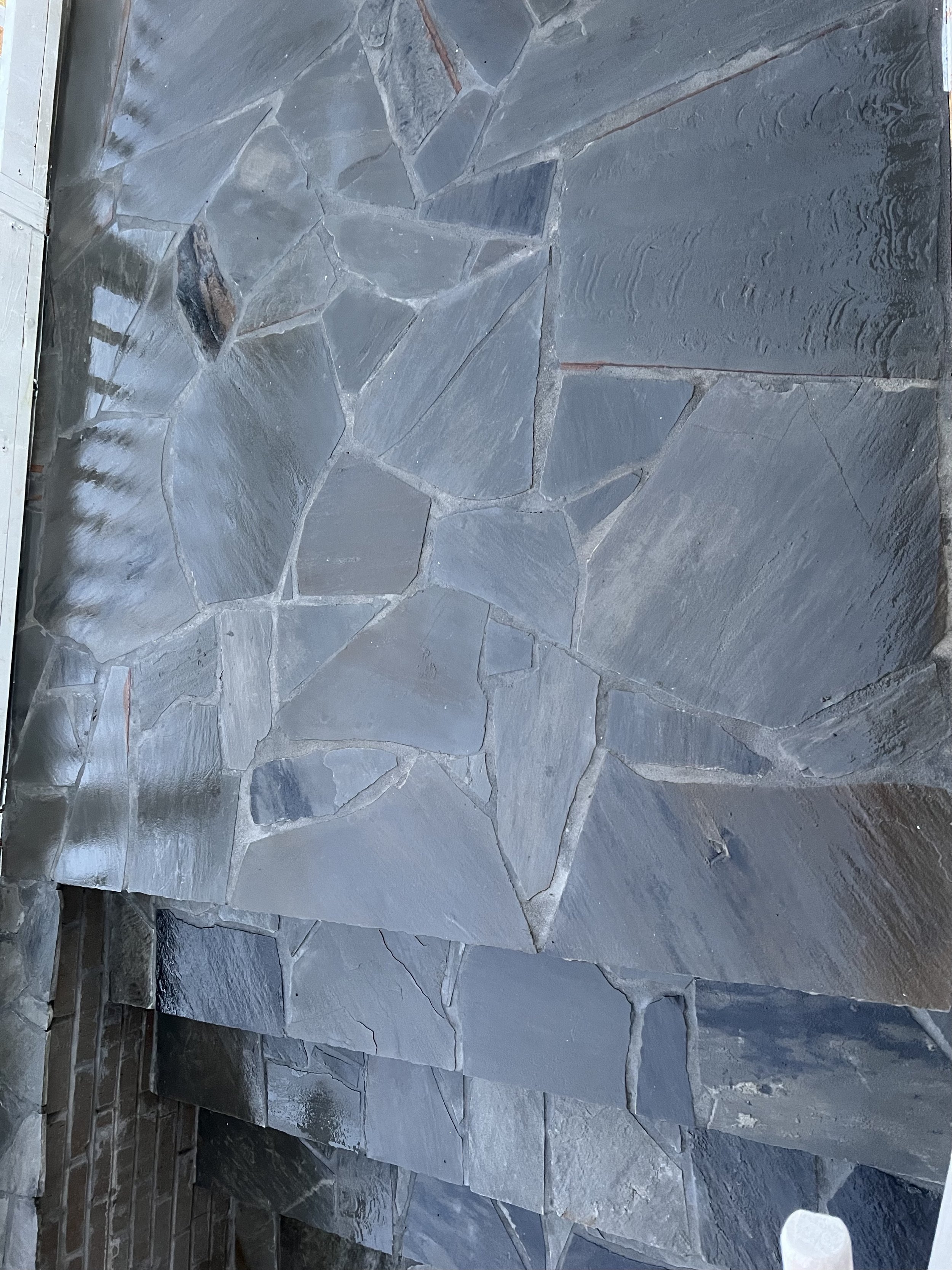 Close-up of a slate stone wall with irregularly shaped stones fitted together.