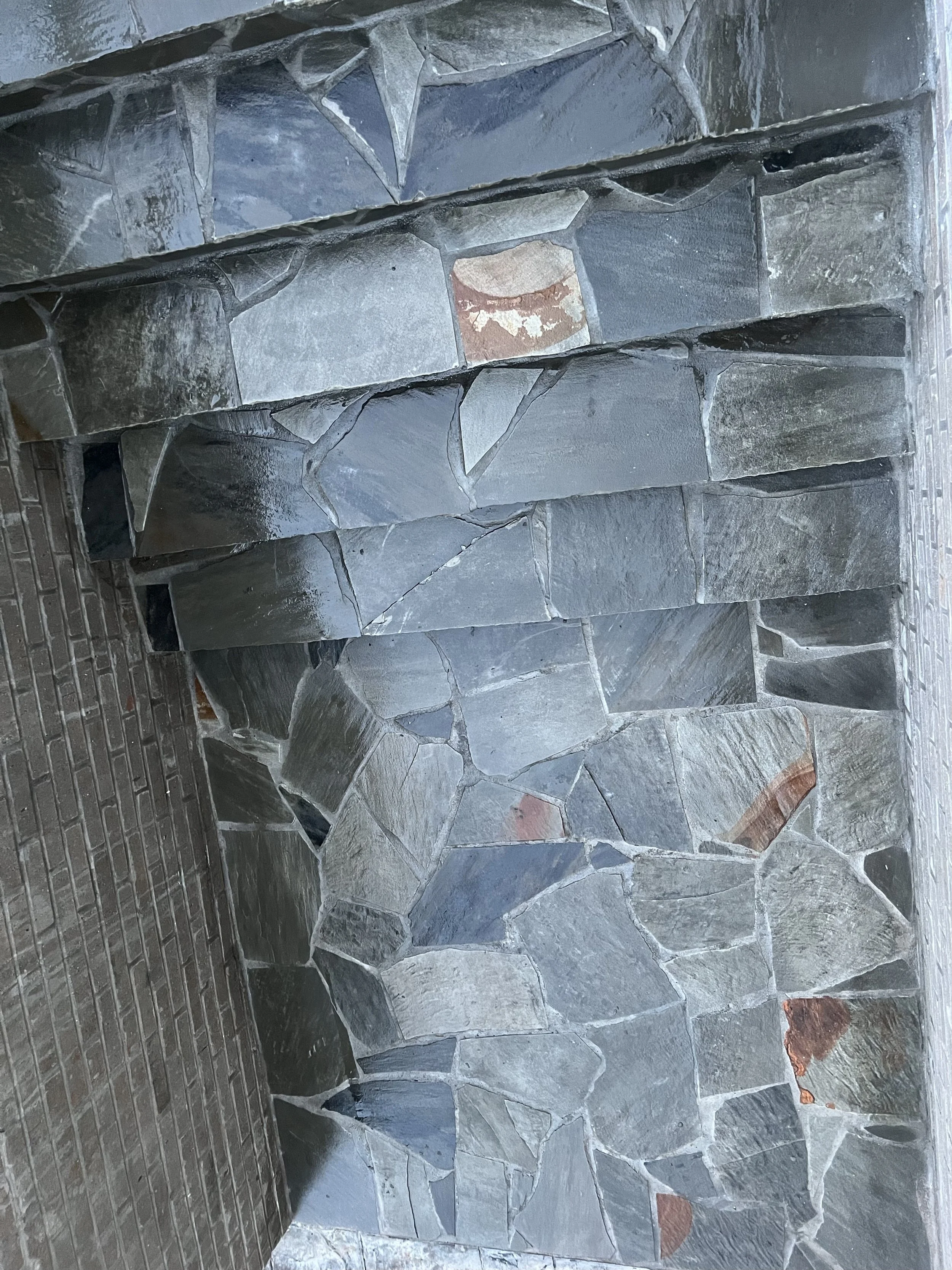 Close-up of a stone fireplace with irregularly shaped gray and black stones.