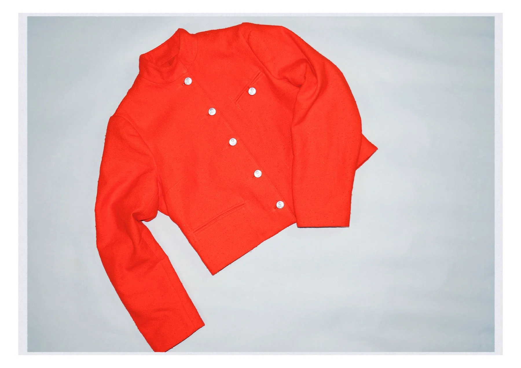 A red long-sleeve shirt and red pants lying on a white surface.
