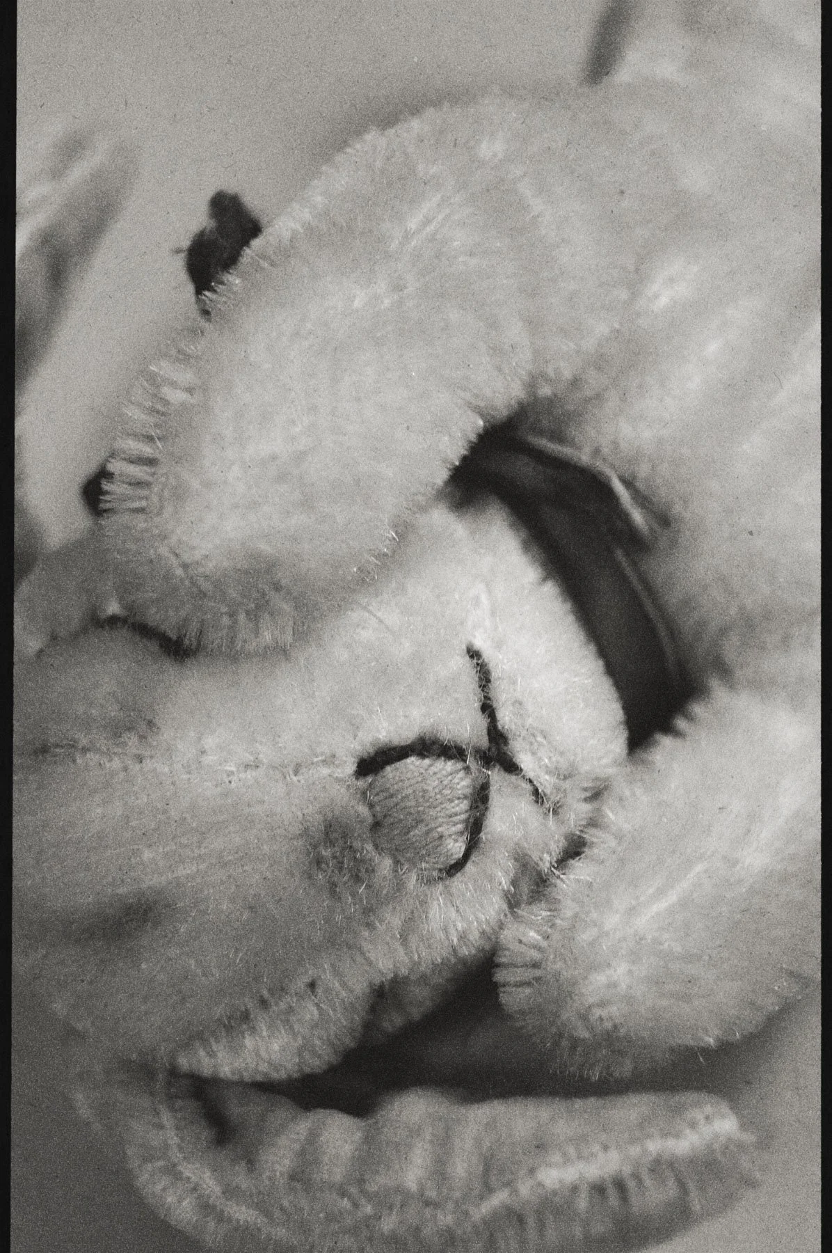 A close-up black-and-white photo of a person shaving, showing razor blades and shaving foam on their face.