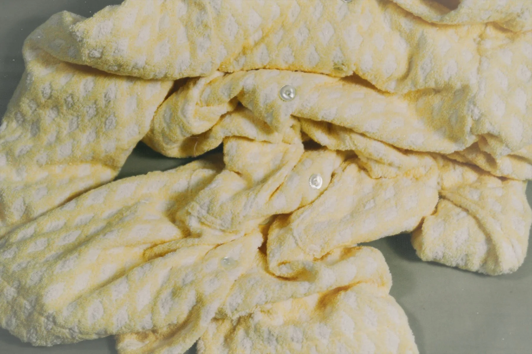Yellow rolled cookies with white powdered sugar, some with tiny pearl-like decorations.