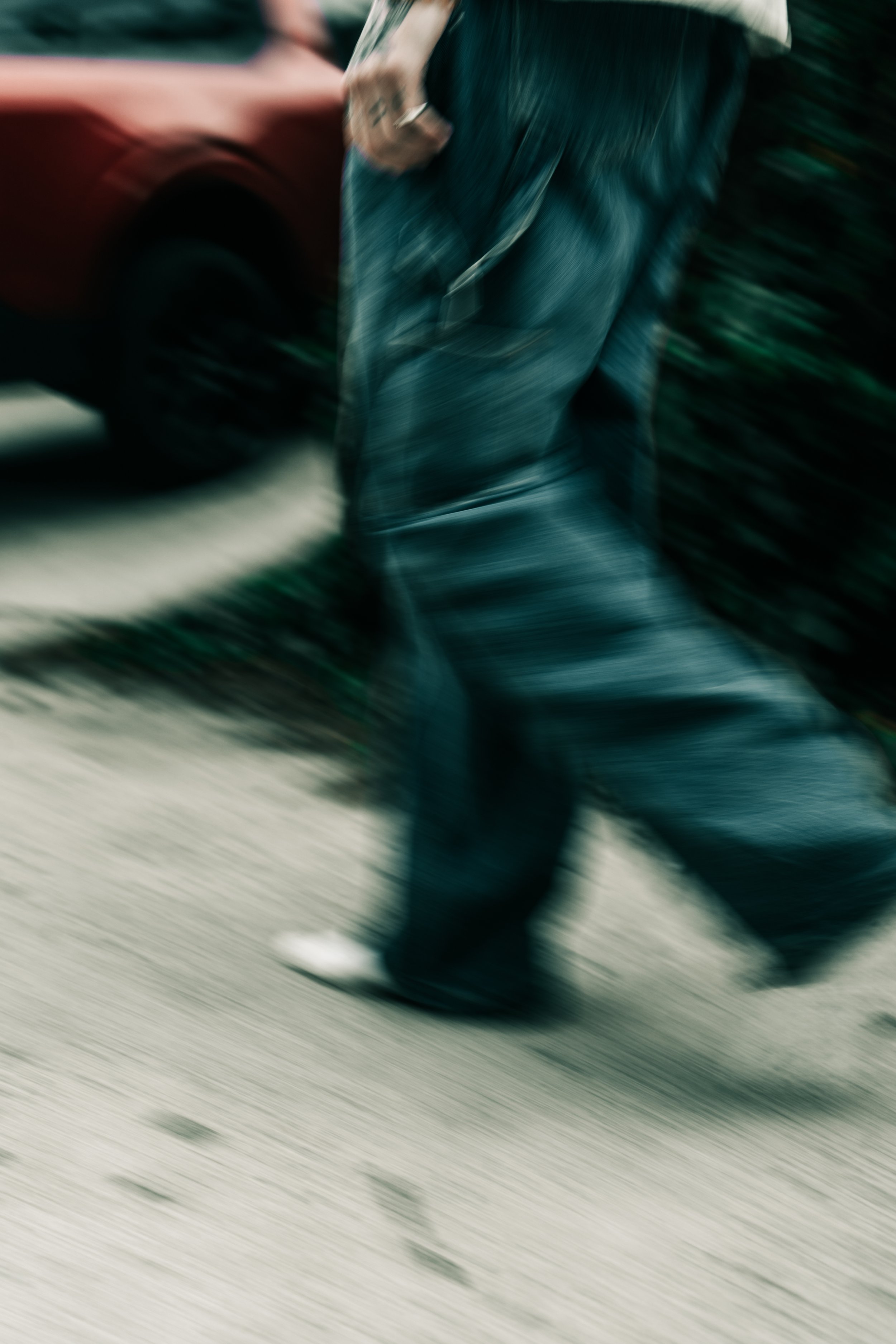 blurred motion shot of walking figure in dark tones, abstract cinematic photography
